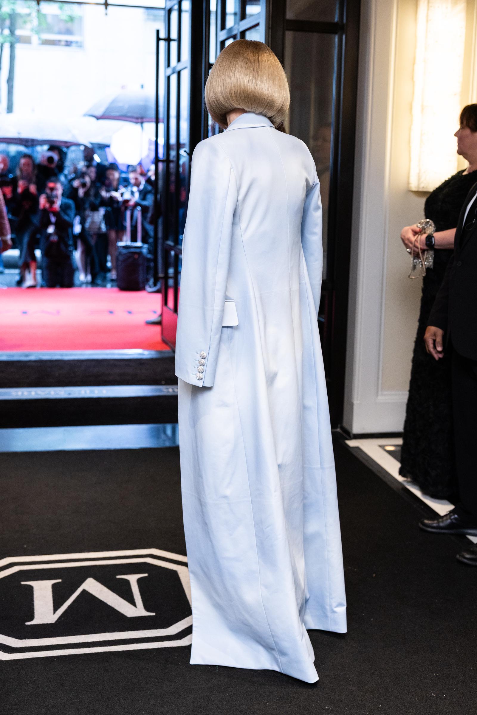 Captured from behind, Anna Wintour makes her way to the venue in her full-length powder blue coat for the 2025 Met Gala, which celebrated "Superfine: Tailoring Black Style" at the Metropolitan Museum of Art.