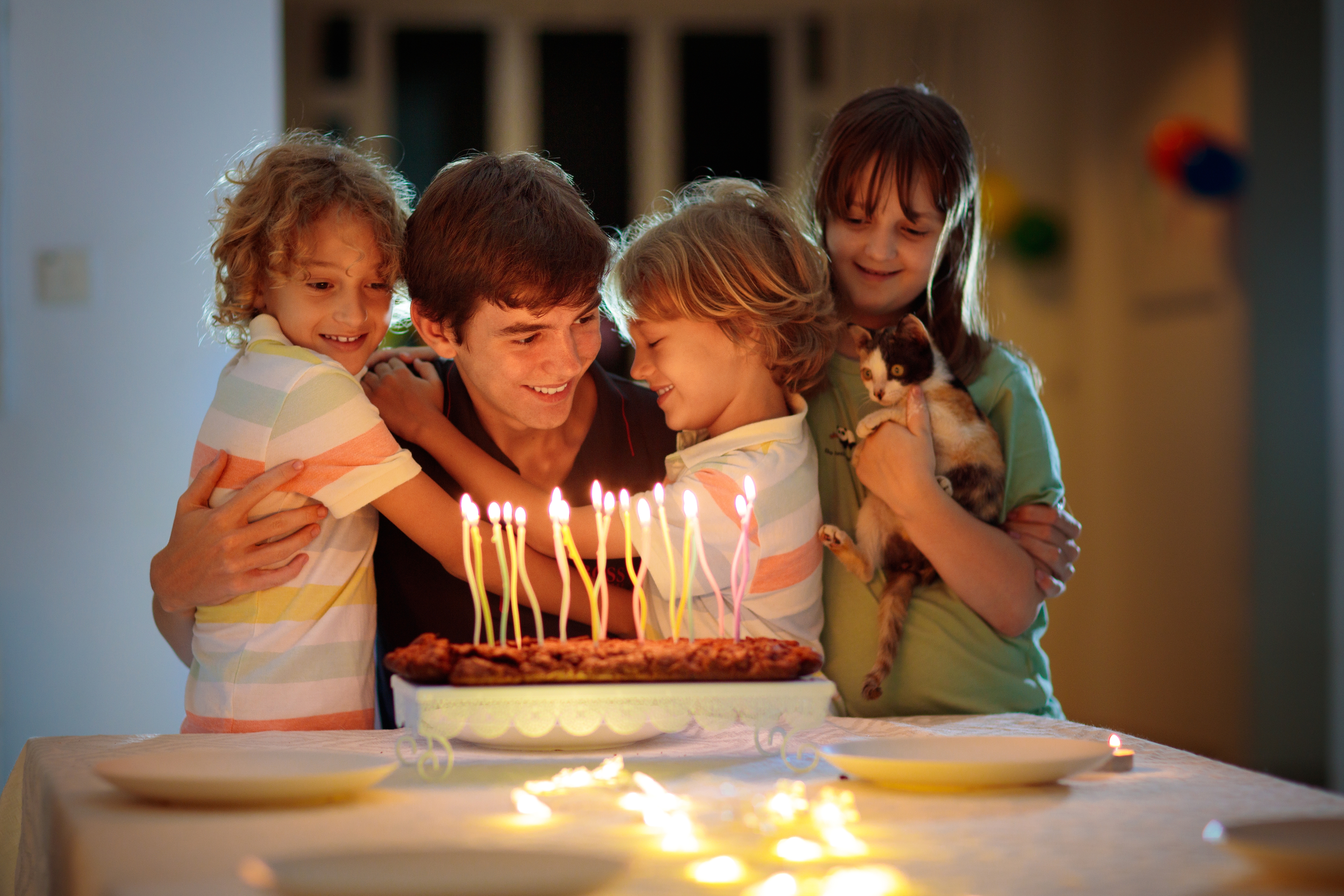 A teenage boy celebrating his birthday with his younger siblings | Source: Shutterstock