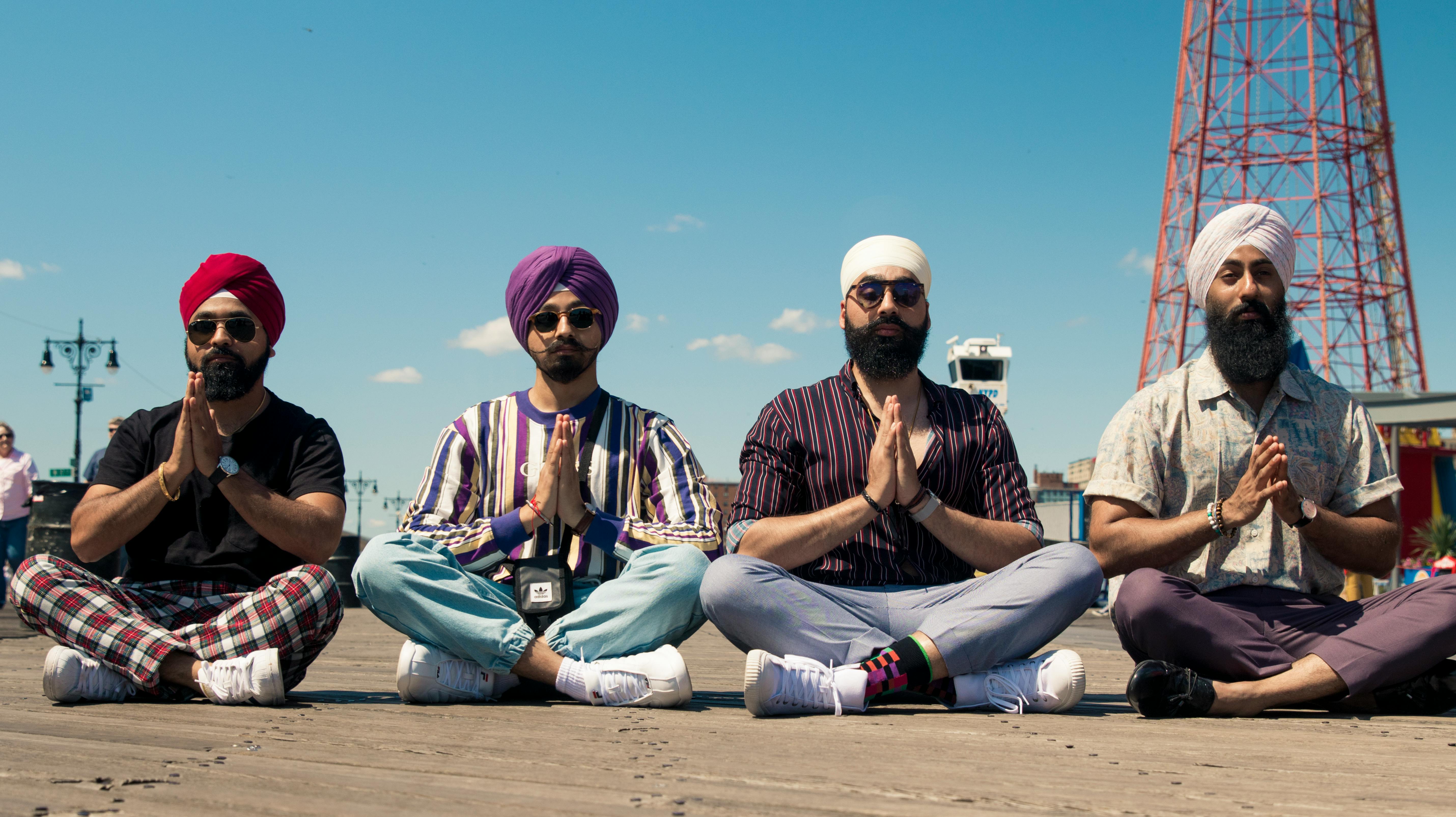 Four men sitting cross-legged with hands in prayer | Source: Pexels