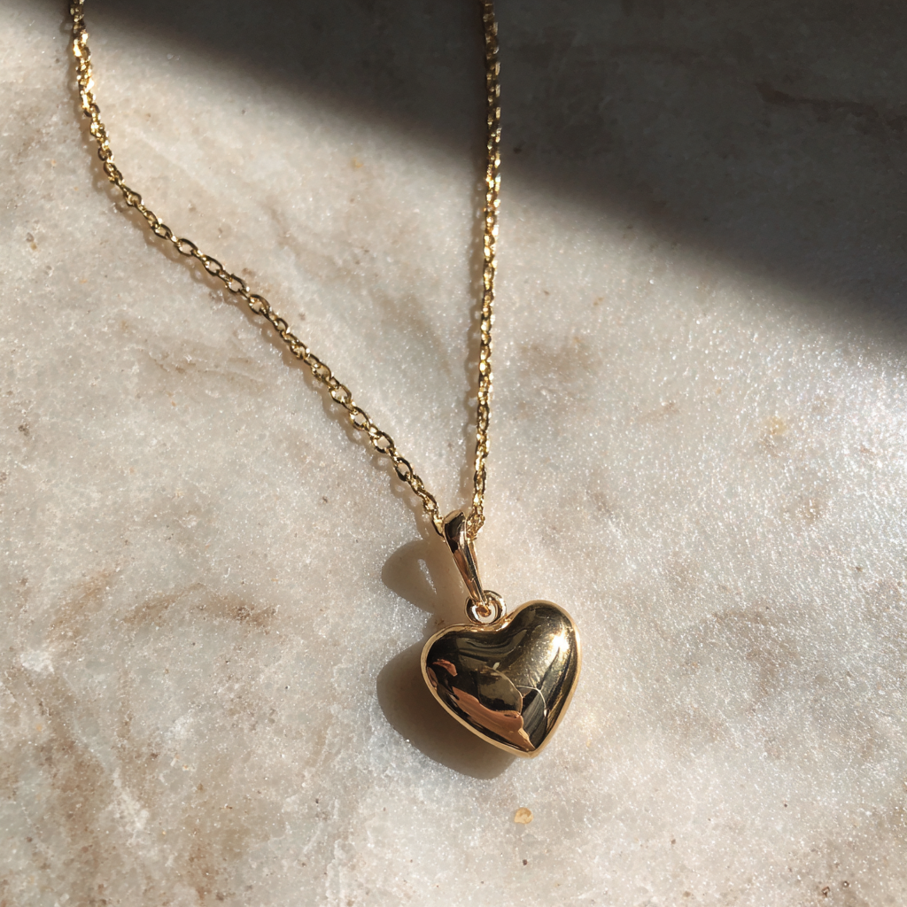 A delicate gold necklace on a counter | Source: Midjourney