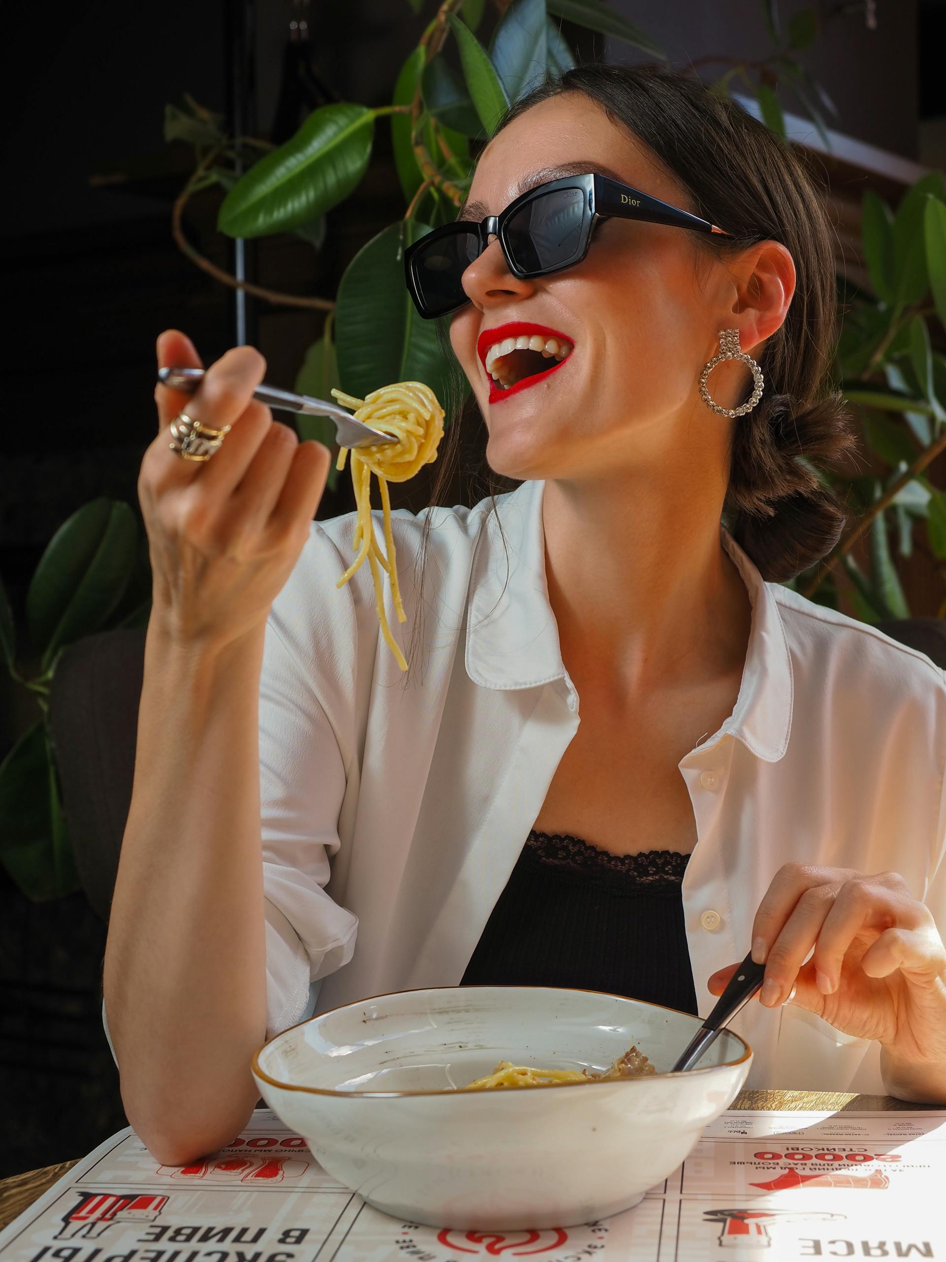 Smiling woman eating in a restaurant | Source: Pexels