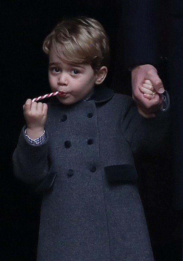 Prince George of Cambridge eats a sweet as he leaves following the service at St Mark's Church on Christmas Day on December 25, 2016 in Bucklebury, Berkshire | Photo: Getty Images
