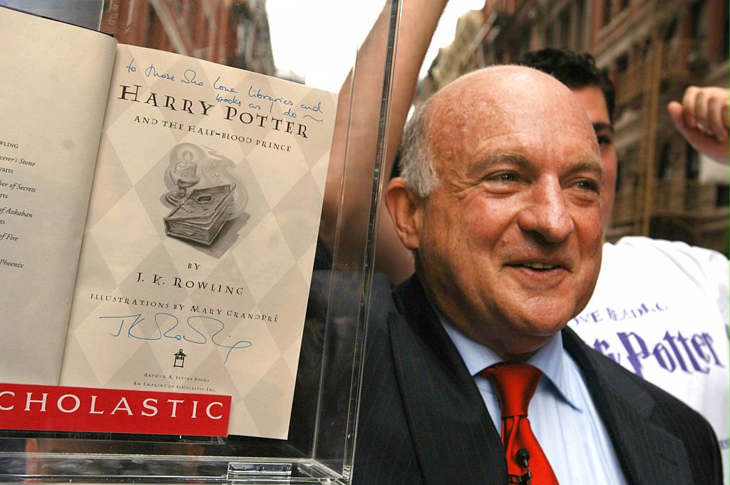 Richard Robinson, président-directeur général de Scholastic Corp., à l'arrière, tient la première édition américaine signée du livre "Harry Potter et le prince de sang-mêlé" lors de son dévoilement à New York, vendredi, juillet 15,2005. | Photo : Getty Images
