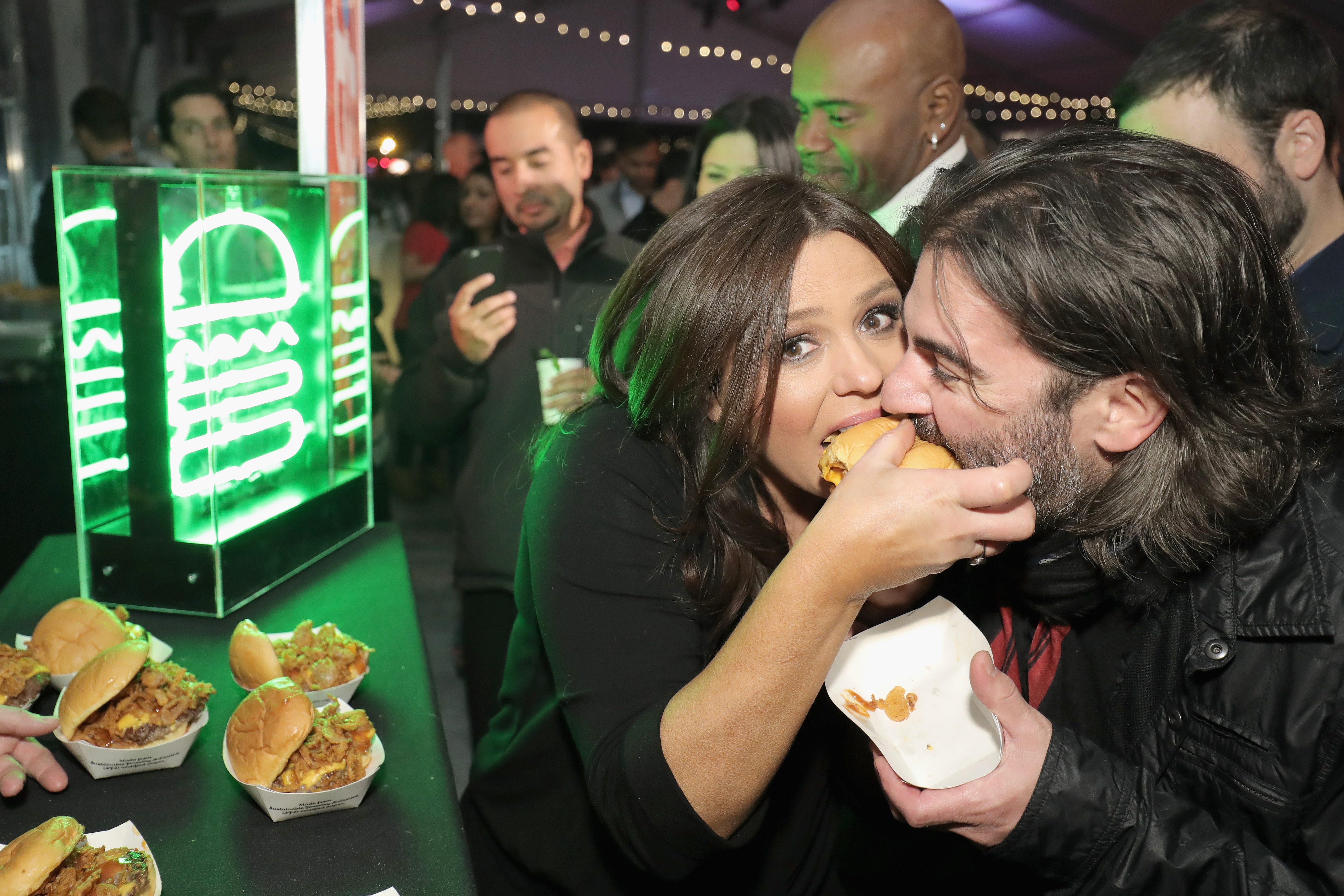 Rachel Ray and her husband John Cusimano dig into a burger at the Blue Moon Burger Bash hosted by Rachael Ray and the Food Network & Cooking Channel at the New York City Wine and Food Festival on October 16, 2016. | Source: Nielson Barnard/Getty Images