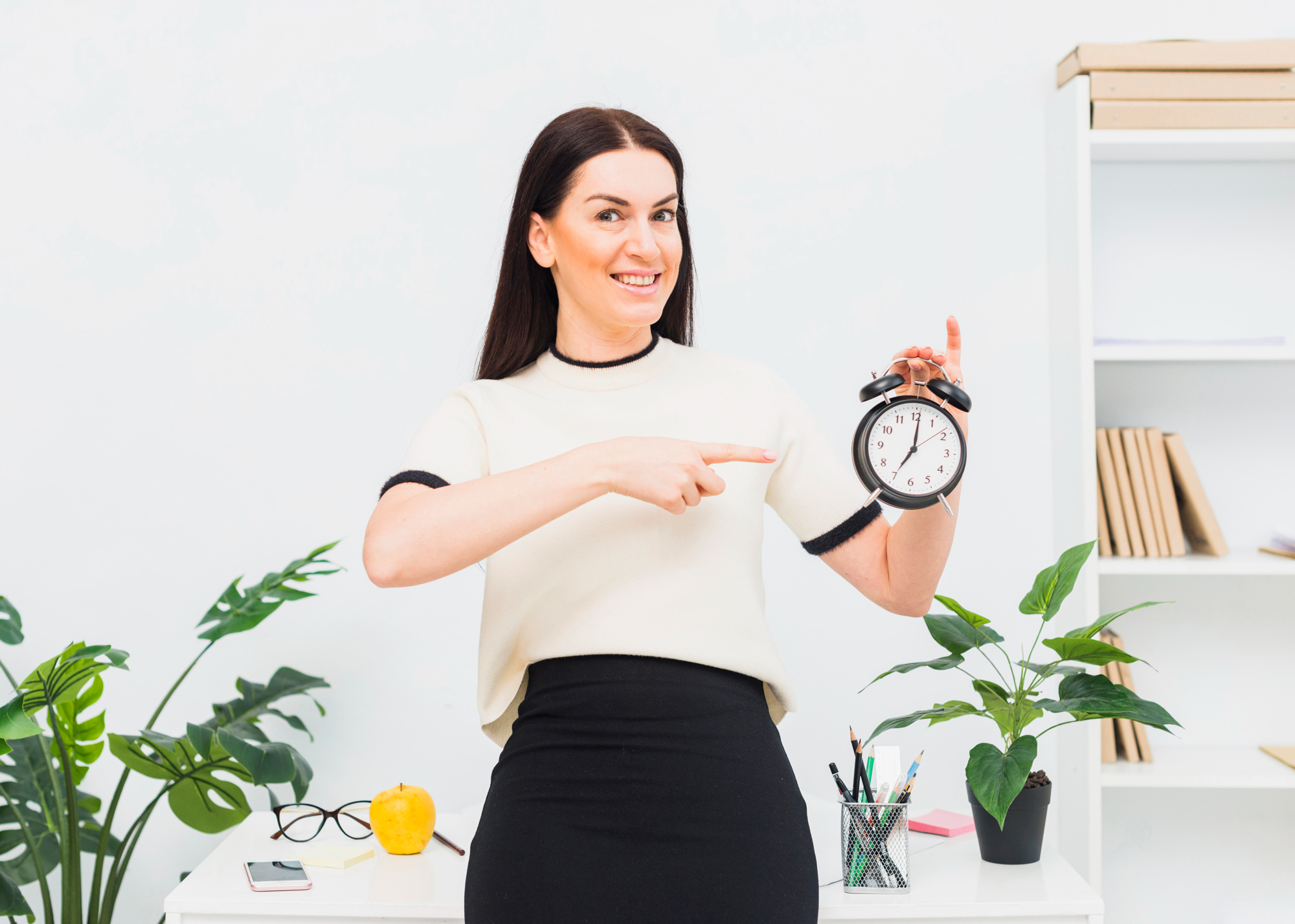 A woman pointing at a clock in her hand | Source: Freepik