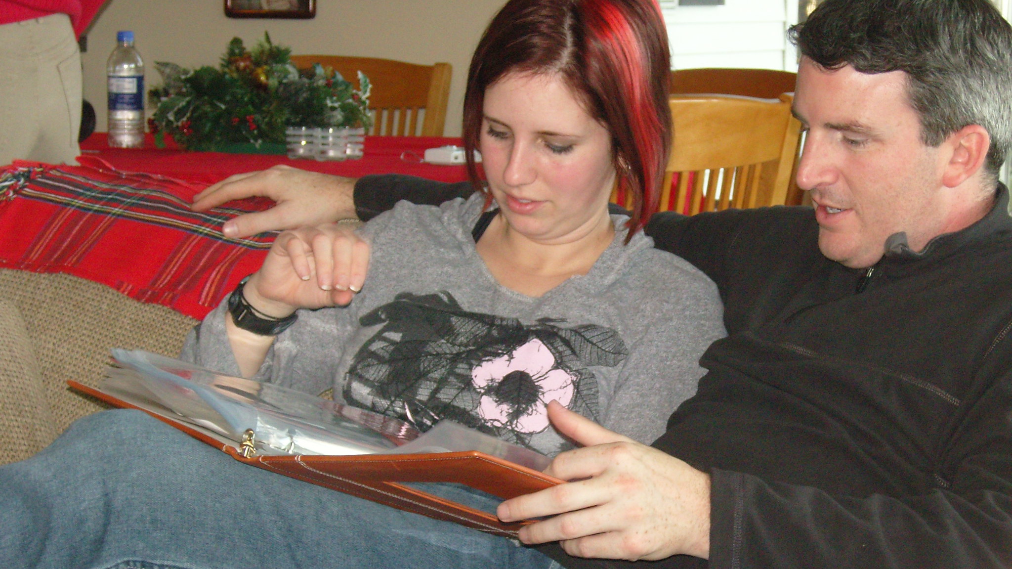 A young woman and older man looking at a photo album | Source: flickr