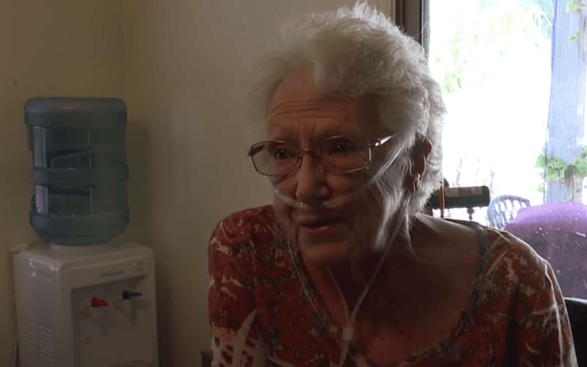 Elderly woman is emotional after students put up her Christmas decorations | Photo: Youtube/KGUN9