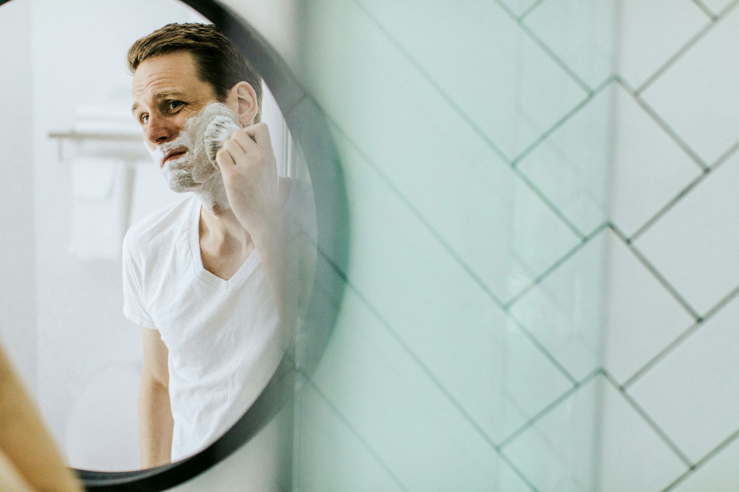 A man shaving in a mirror | Source: Unsplash