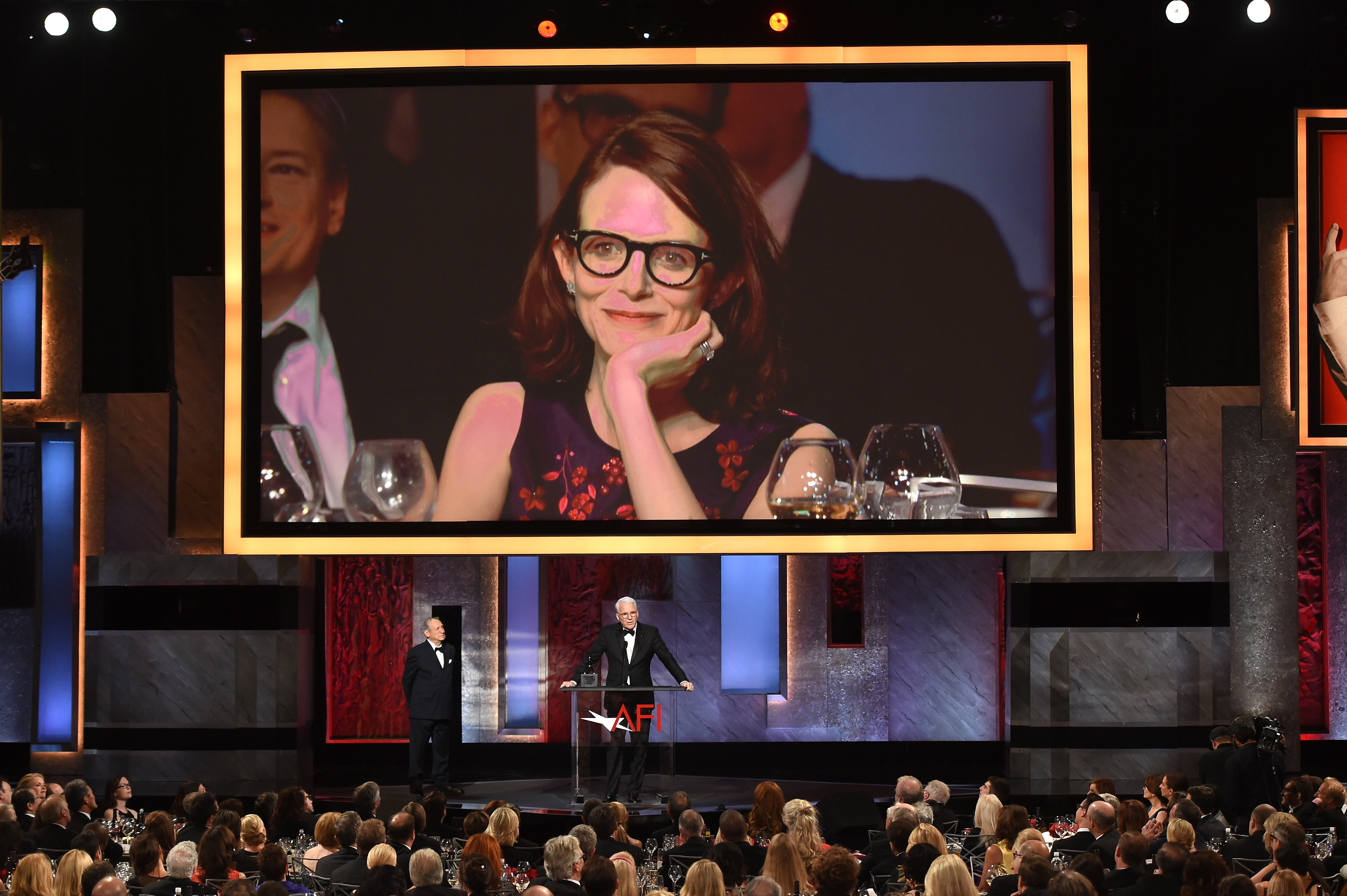An image of Anne Stringfield appears on a video screen as honoree Steve Martin accepts the AFI Life Achievement Award at the Dolby Theater on June 4, 2015, in Hollywood, California. | Source: Getty Images