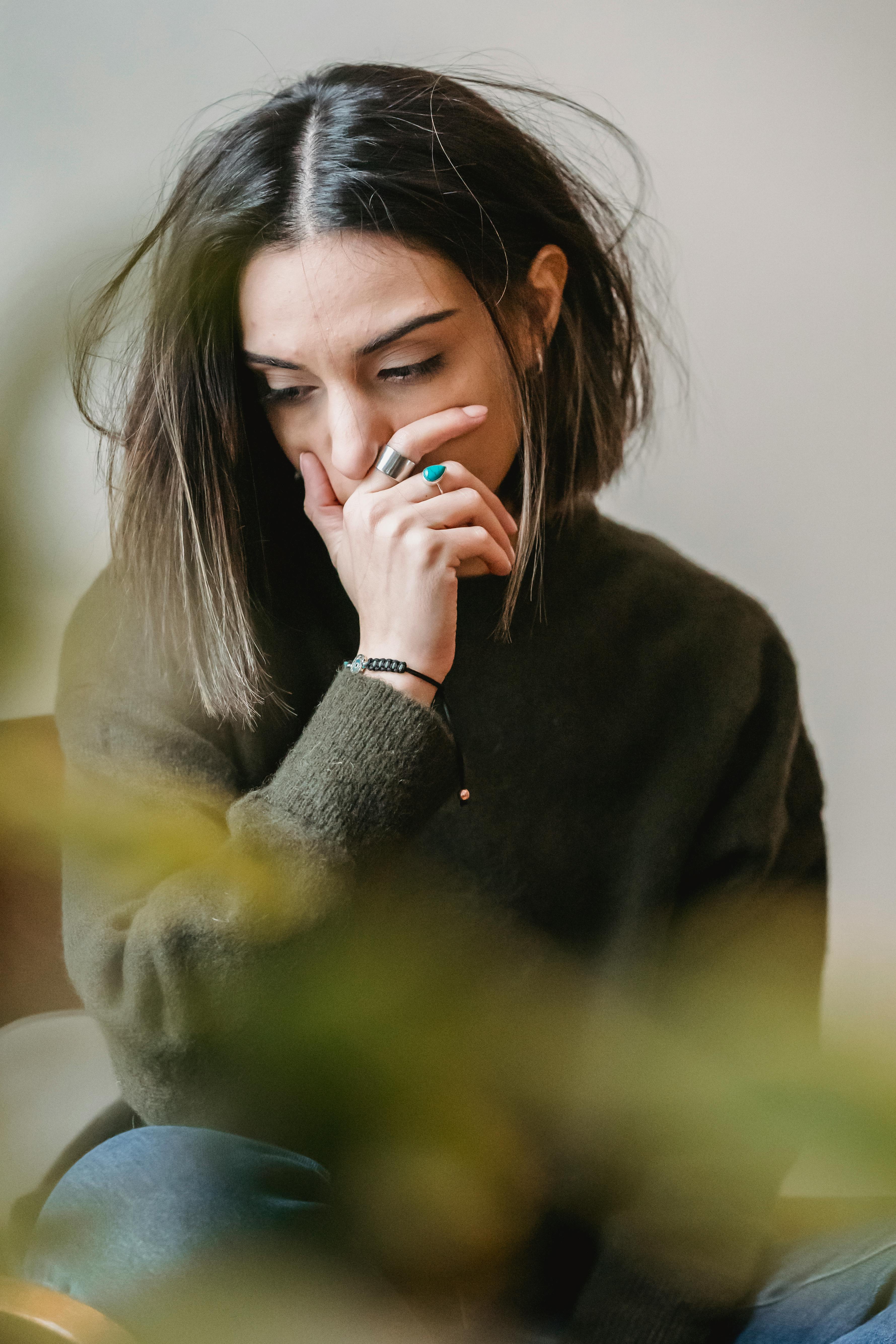 An upset woman with her hand on her mouth | Source: Pexels