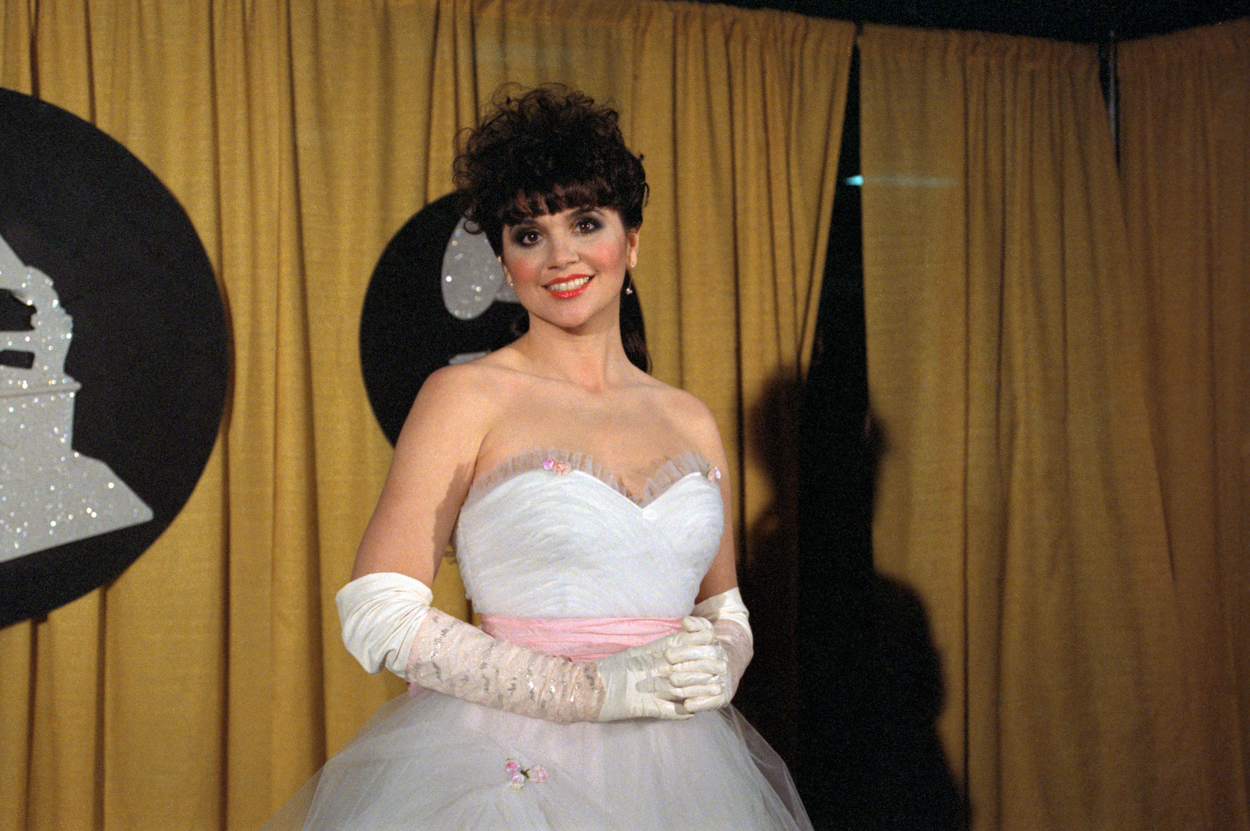 Linda Ronstadt posing in a white gown at Grammy Awards on February 28, 1984.┃Source: Getty Images