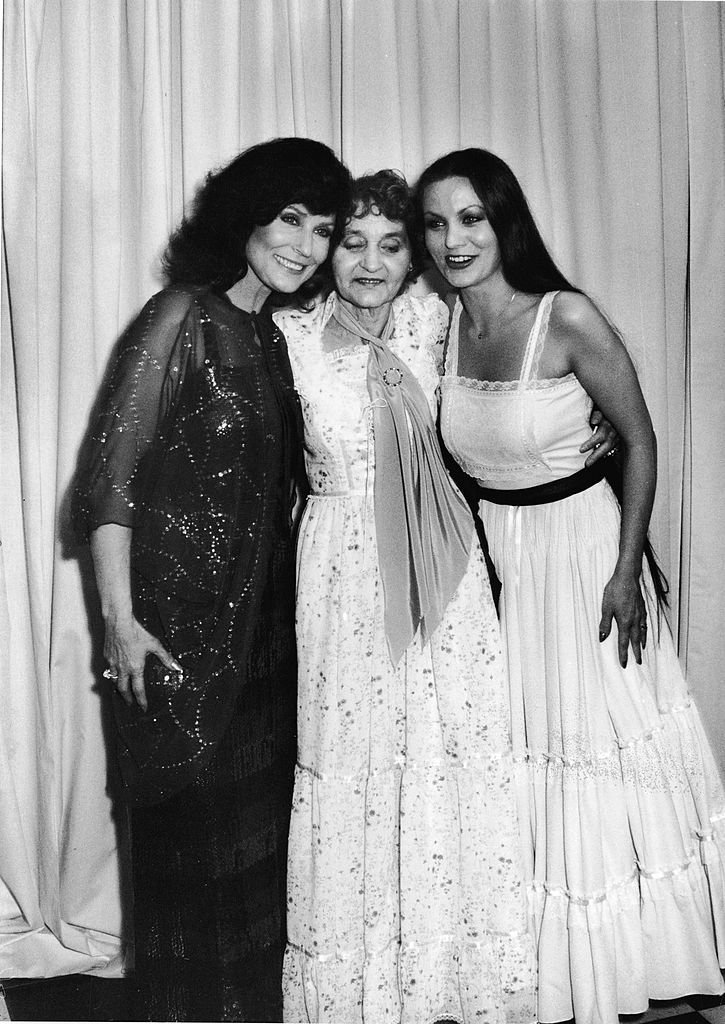 American country music singer and guitarist Loretta Lynn (L) poses with her mother, Clara Webb Butcher (1907 - 1981), and her sister Crystal Gayle (R), also a county music singer, at the Country Music Awards, California, March 1, 1980. | Source: Getty Images