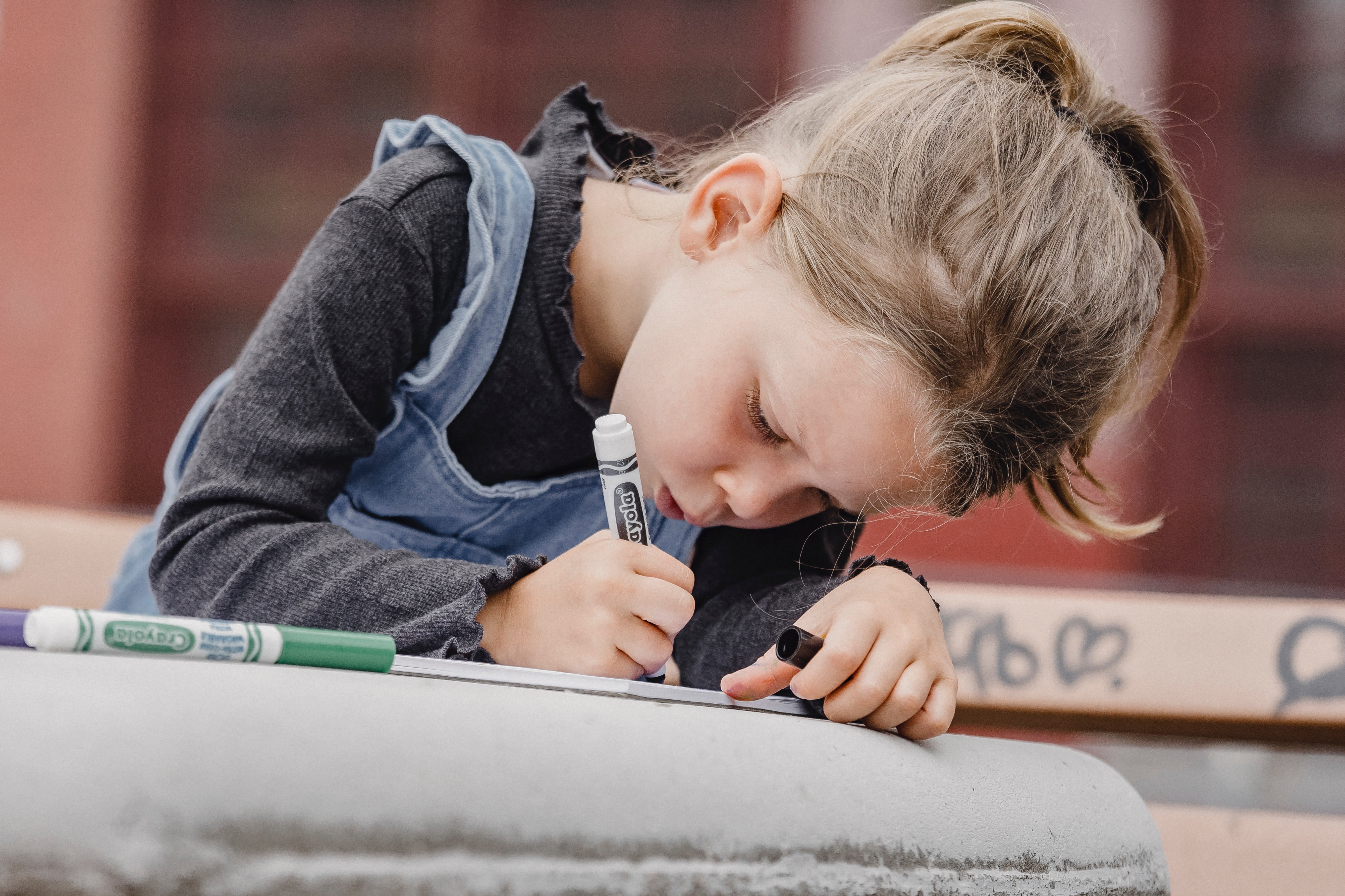 Meg was sitting at a picnic table, coloring. | Source: Pexels