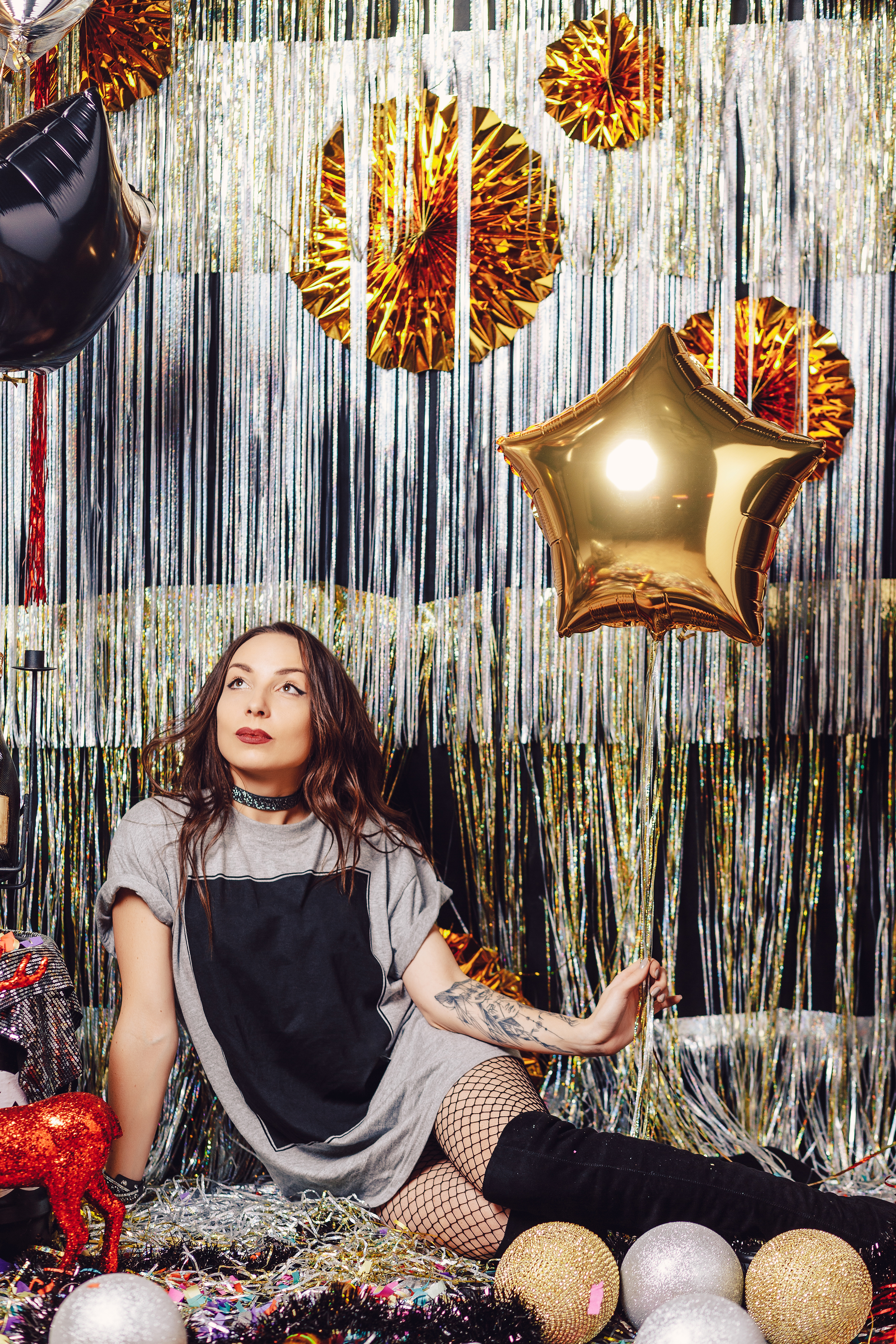 Teen girl in sitting against a birthday party backdrop with metallic balloons | Source: Freepik