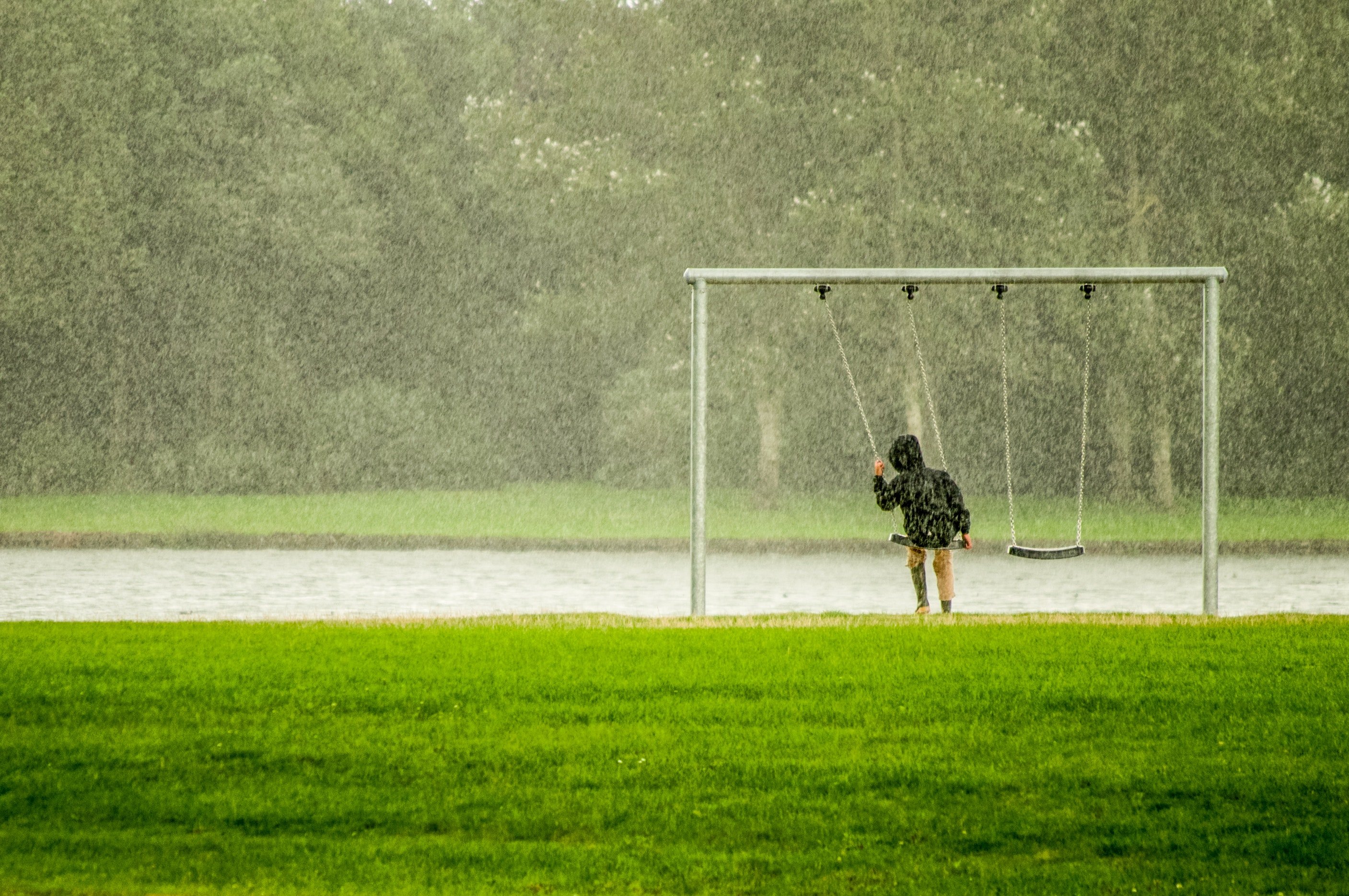 A child swinging in the rain. | Pexels/ Skitterphoto