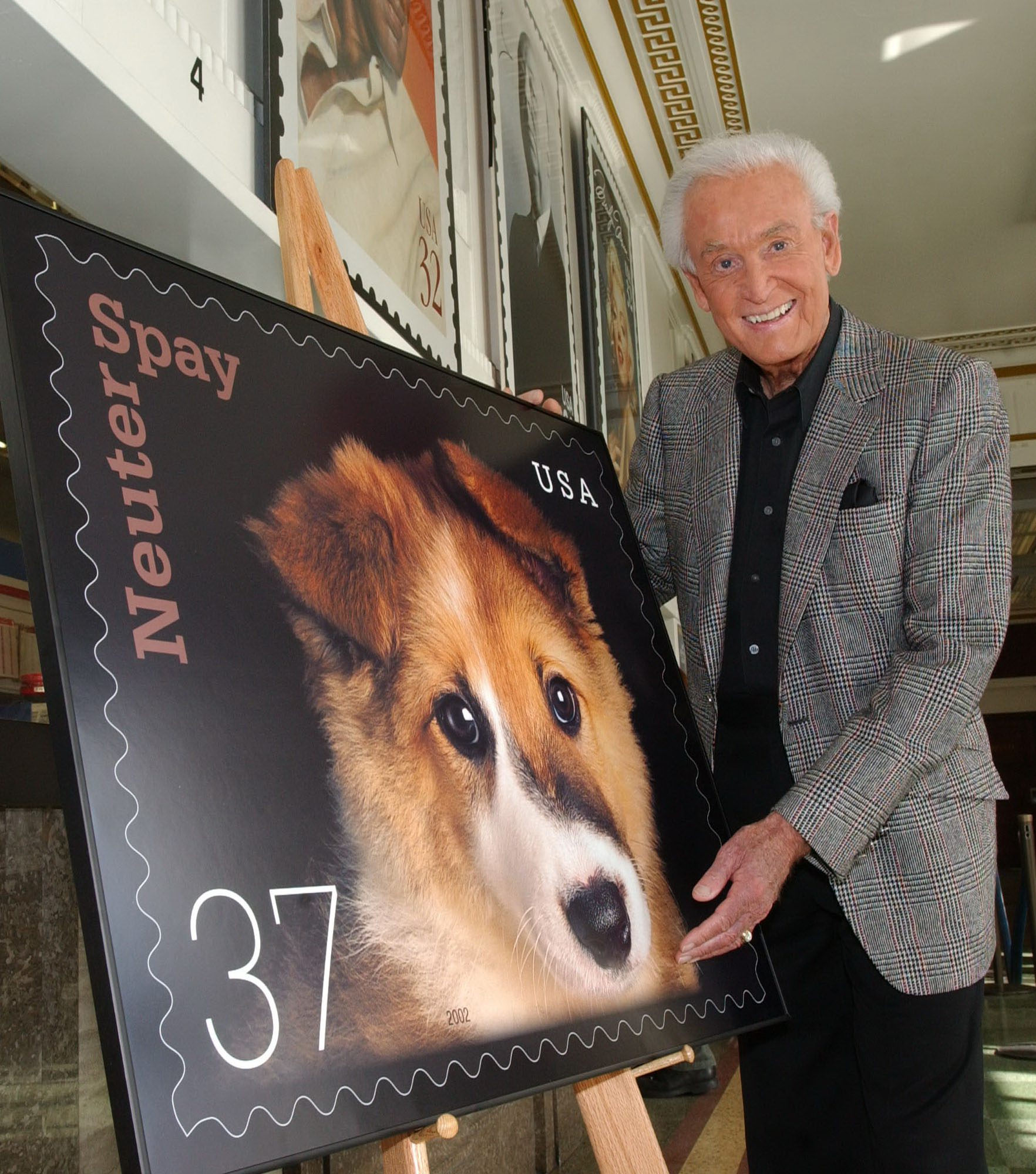 Bob Barker posing with an animal rights initiative poster in 2002 | Source: Getty Images