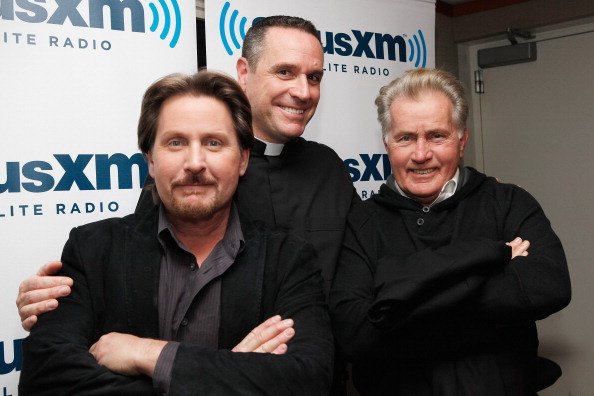  Emilio Estevez and Martin Sheen pose with Busted Halo host Father Dave (C) at SiriusXM Studio on October 7, 2011, in New York City. | Source: Getty Images.