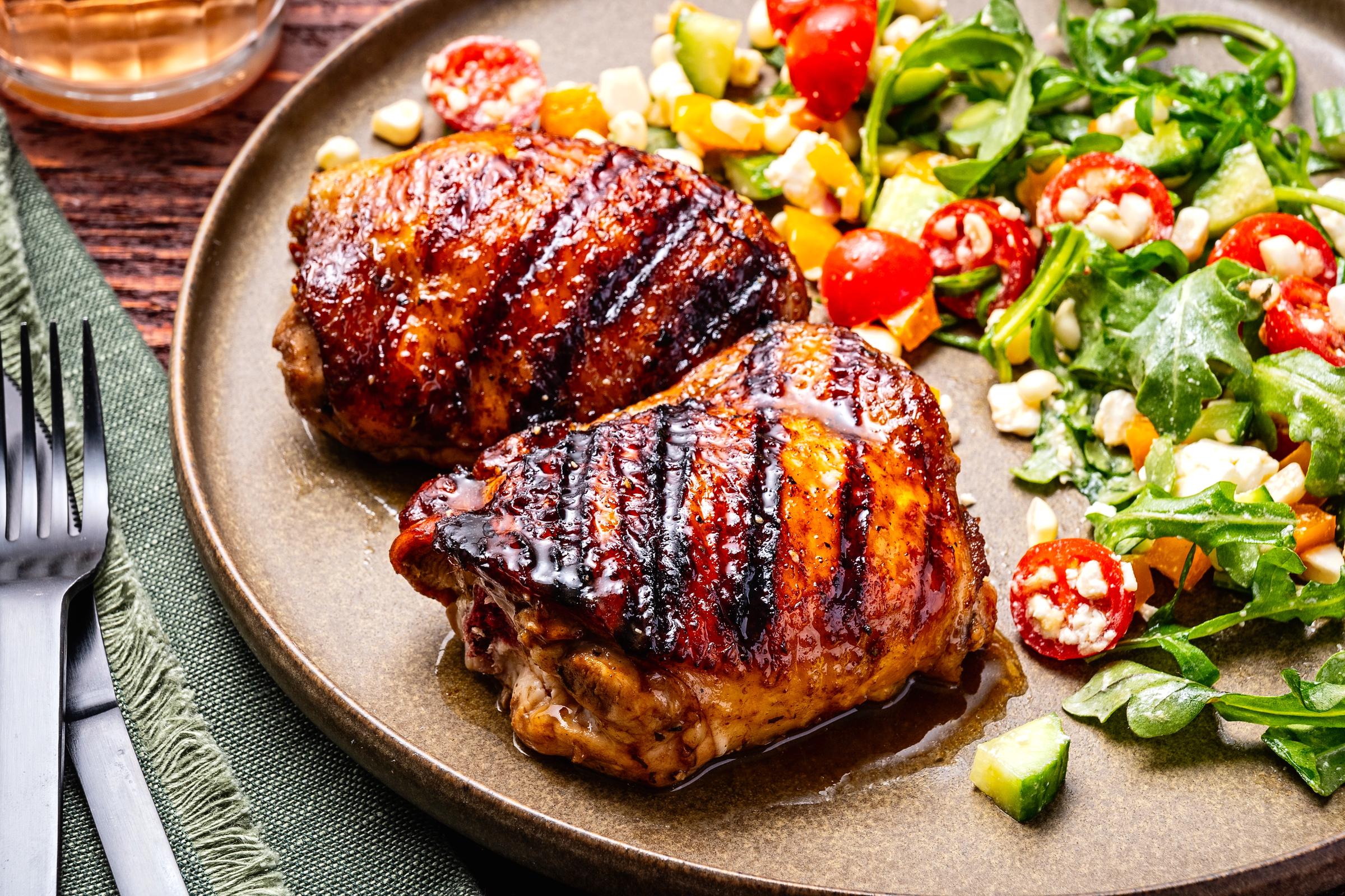 Grilled chicken thighs and a salad photographed for a food outlet; photo taken in Washington, D.C. on June 17, 2024. | Source: Getty Images