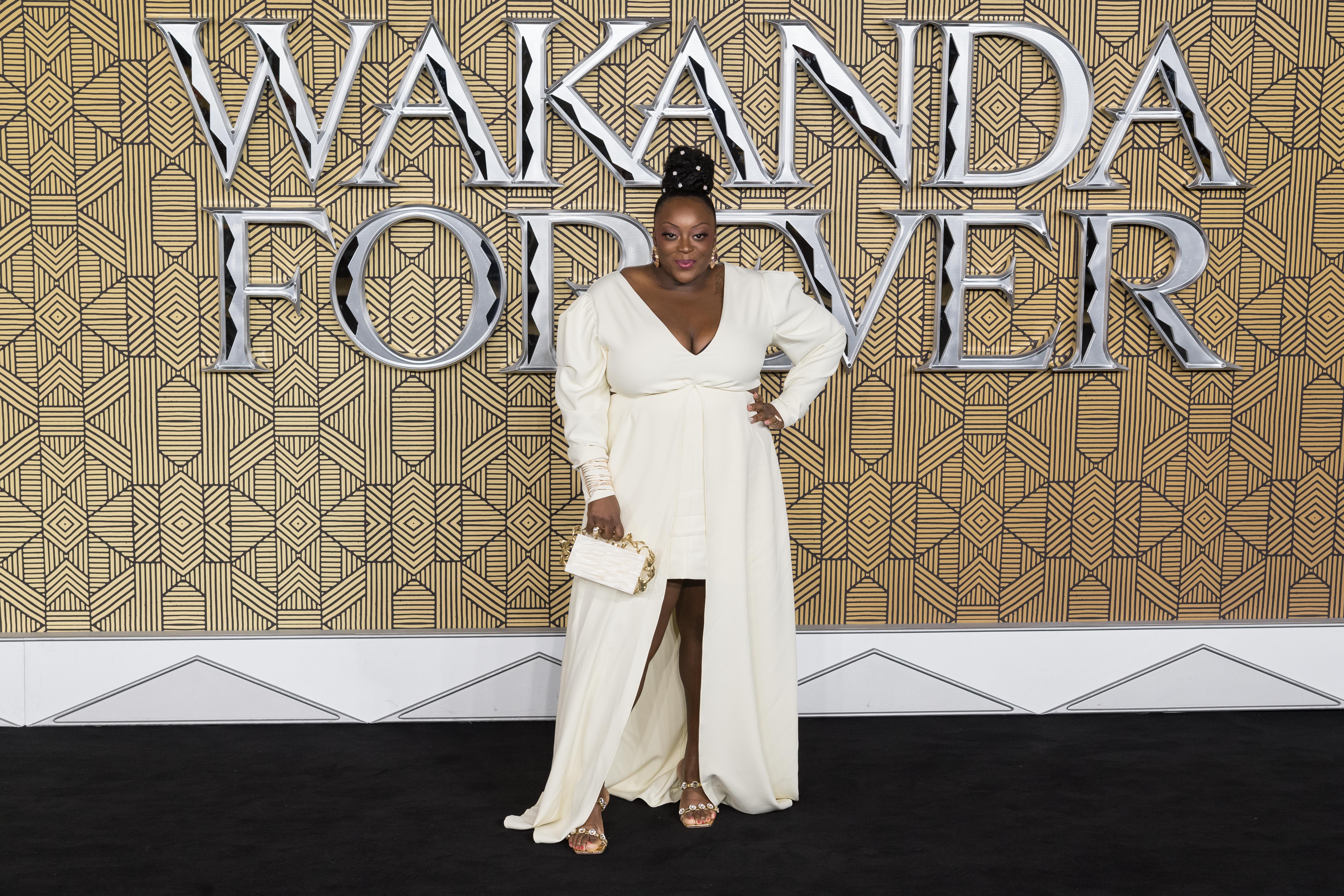 Love turns every head at the star-studded European premiere of "Black Panther: Wakanda Forever" in Leicester Square. Dressed in an ethereal ivory gown with a daring thigh-high slit, the comedian adds a touch of gold with sleek heels and a matching clutch, posing like a queen against the bold Wakandan-themed set.