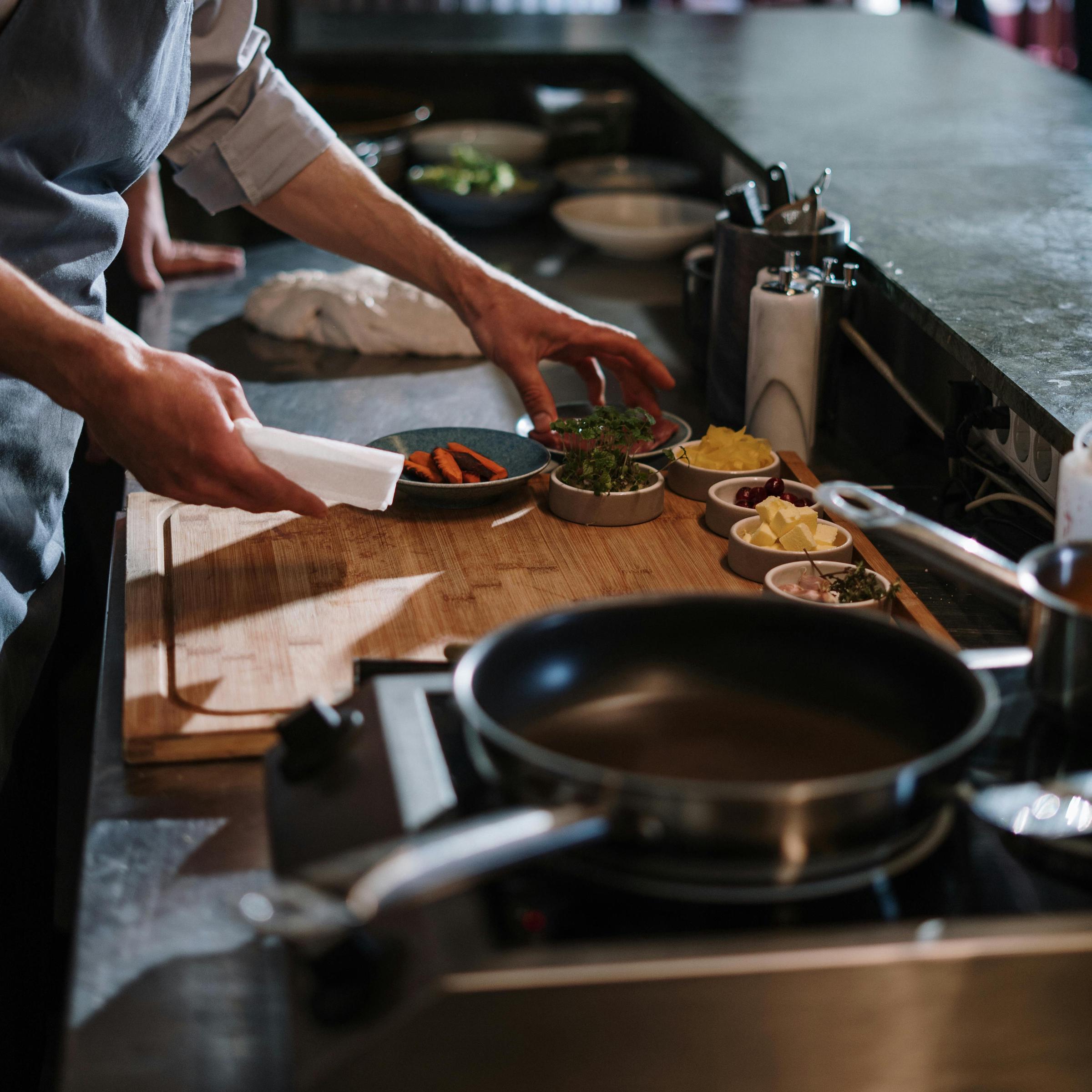 A man prepares to cook with a variety of foodstuffs and utensils | Source: Pexels