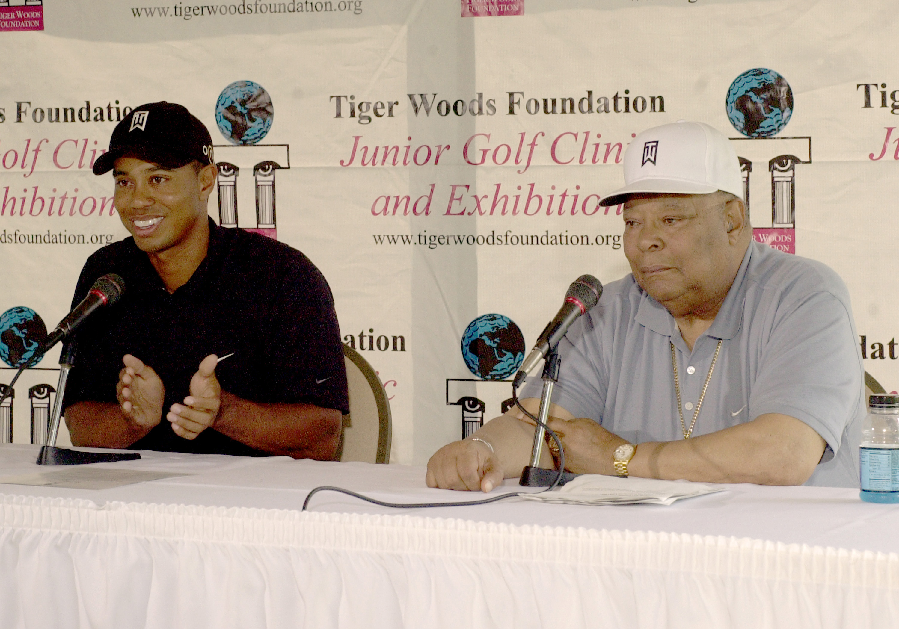 Tiger Woods sits with his dad, Earl Woods, as they announce the new site for the Tiger Woods Learning Center at the H.G. "Dad" driving range on August 28, 2004, in Anaheim, California | Source: Getty Images