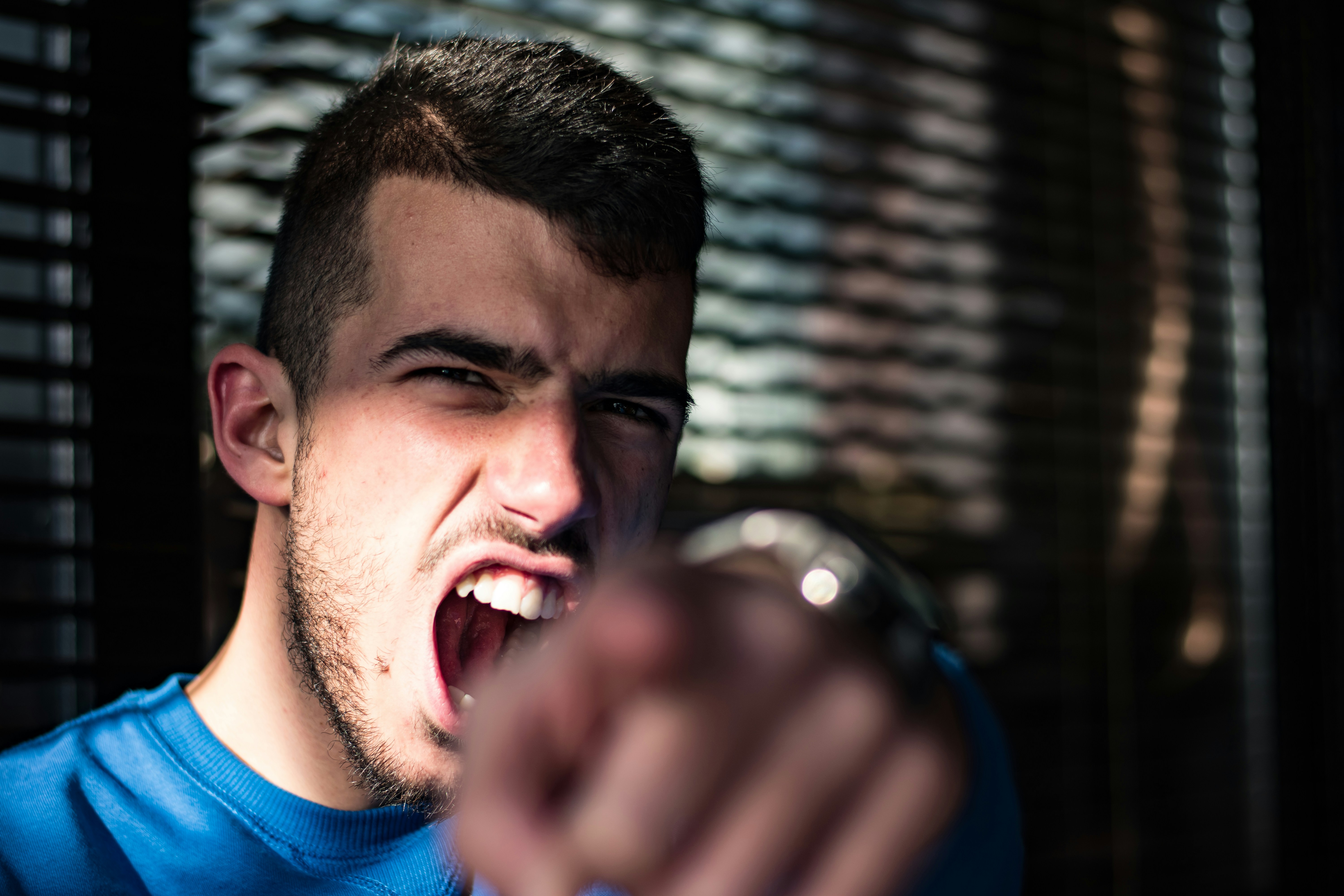 An angry man pointing and shouting | Source: Unsplash