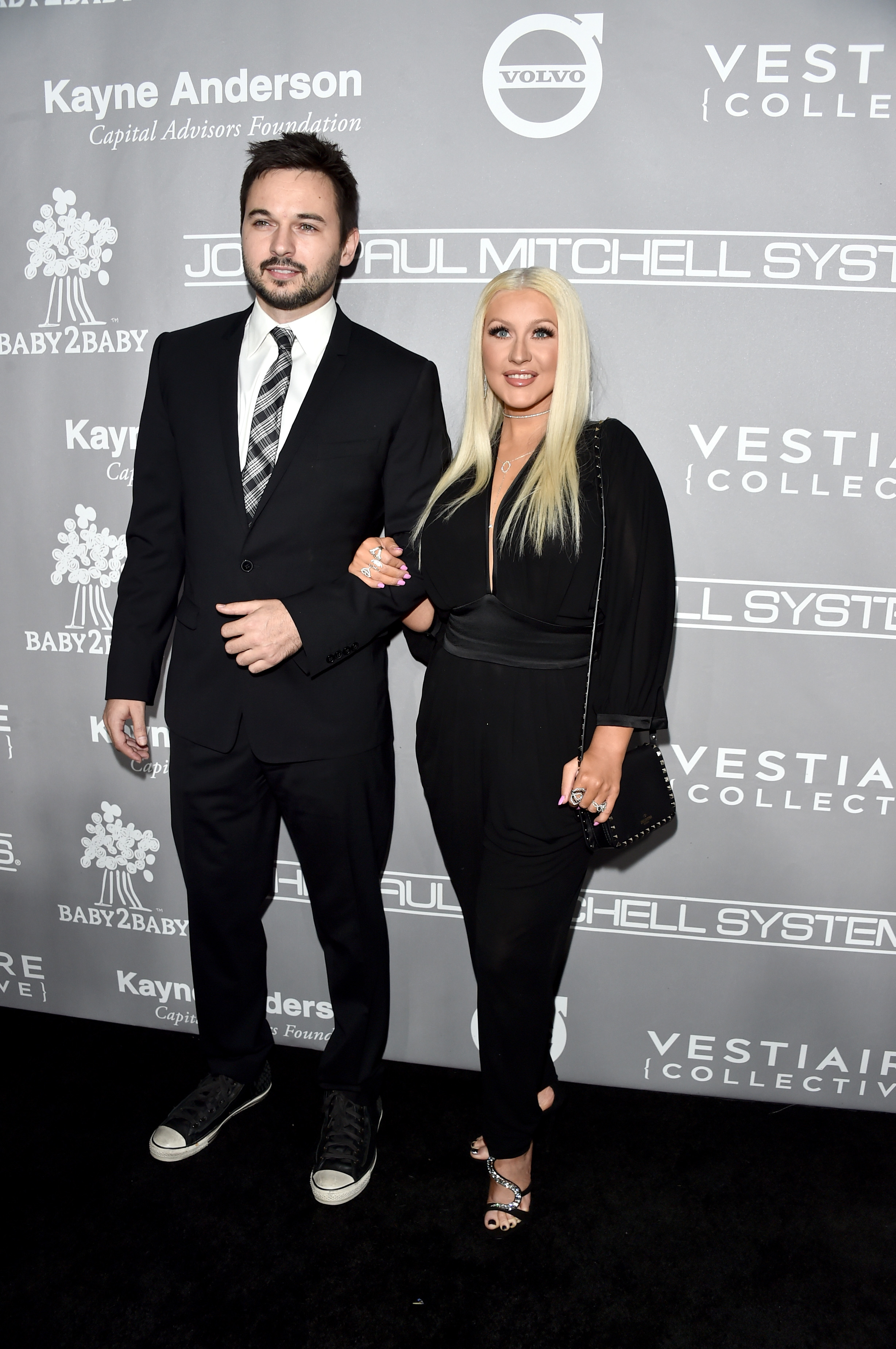 Matthew Rutler and Christina Aguilera appear at the Baby2Baby Gala in coordinated black looks, with Aguilera linking arms with Rutler on the red carpet.