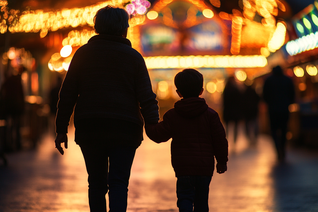 Silhouette of a little boy walking with his grandma | Source: Midjourney