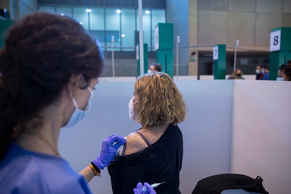 Un agent de santé vaccine une femme. |Photo Getty Images