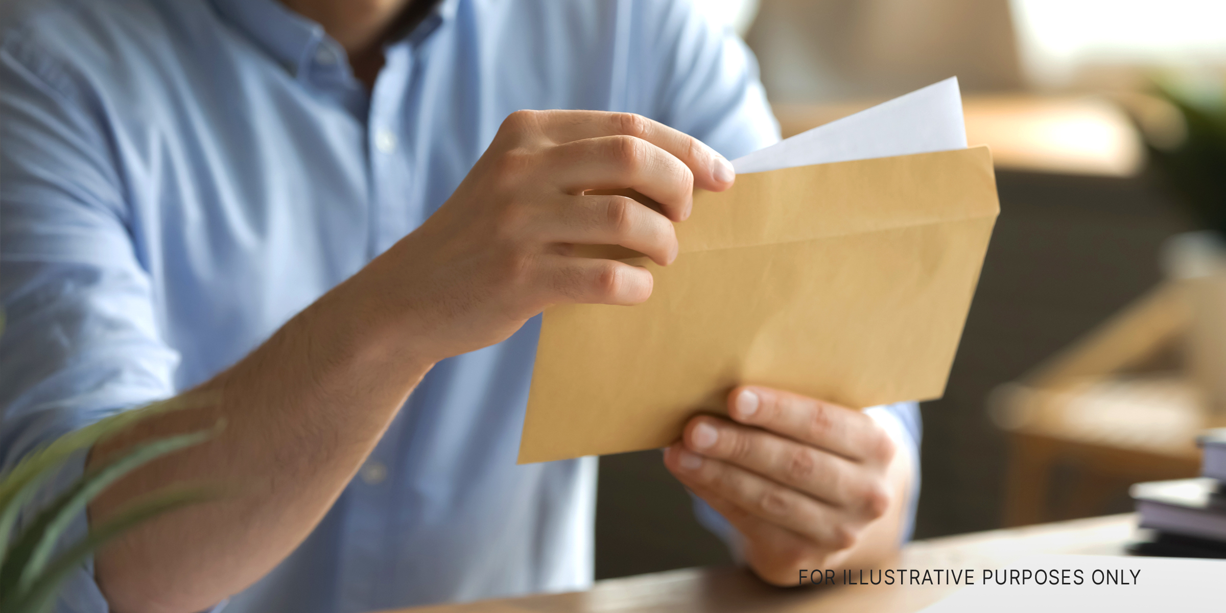 A man opening an envelope and removing a letter | Source: Shutterstock