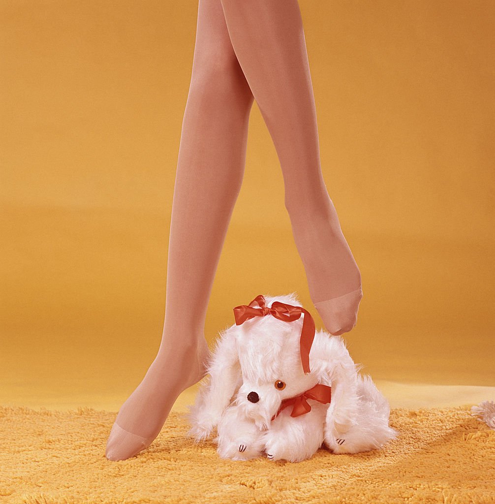 Ein Model in hauchdünnen Strumpfhosen posiert mit einem Stofftier, circa 1970 | Quelle: Getty Images