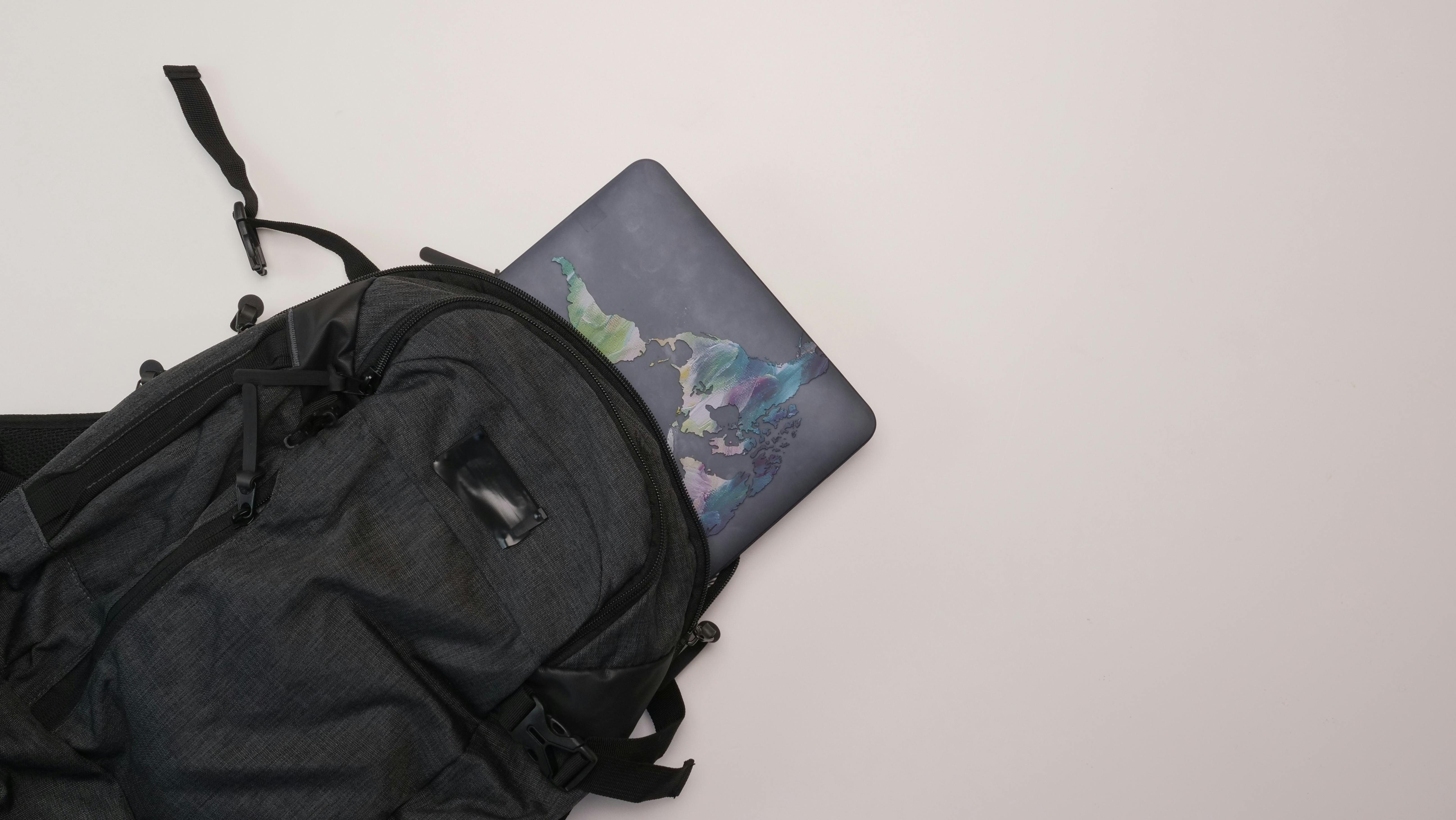 Laptop peeking out of a black backpack. | Source: Pexels