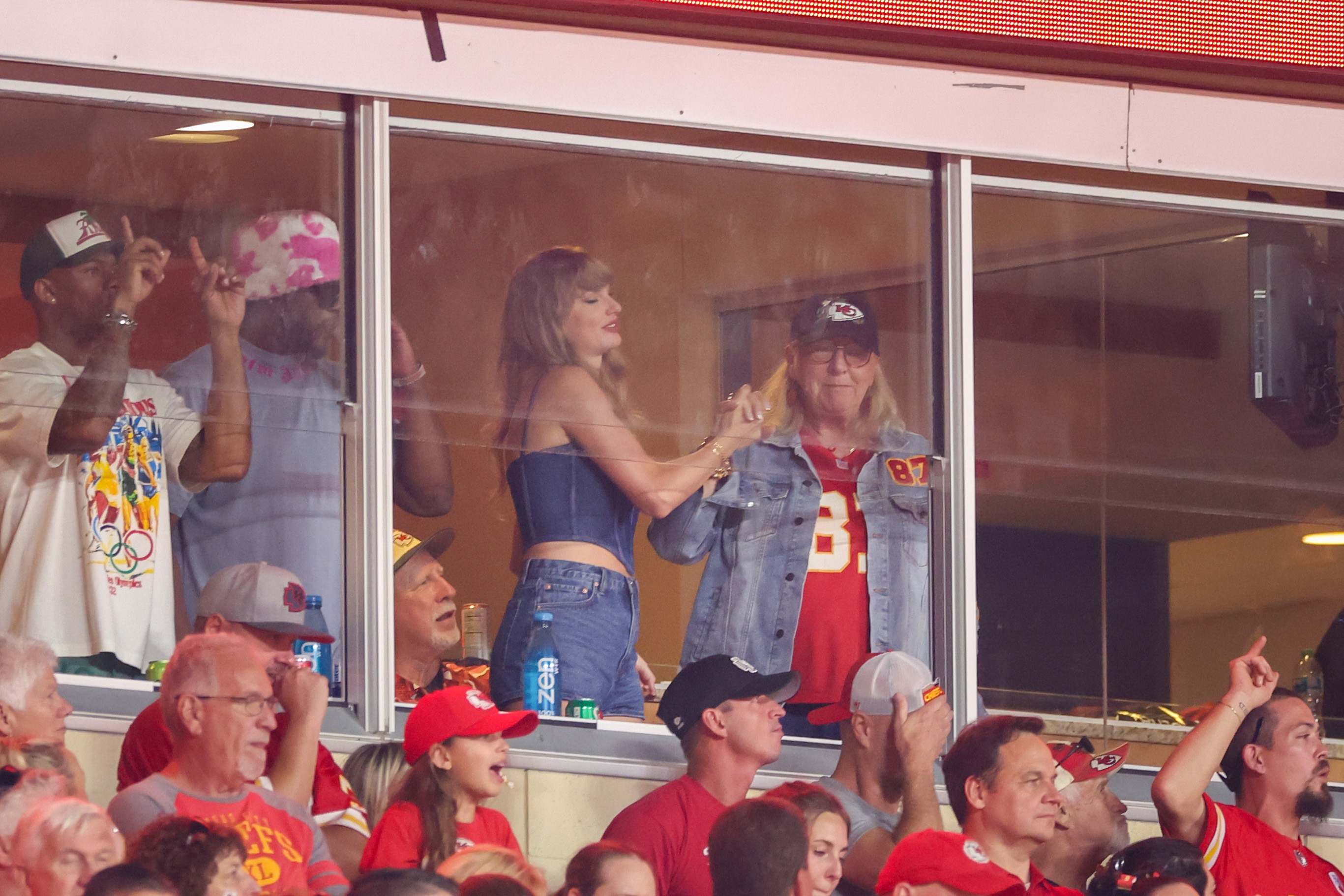 Taylor Swift and Donna Kelce high-fiving and watching the game between the Kansas City Chiefs and Baltimore Ravens in Kansas City, Missouri on September 5, 2024 | Source: Getty Images