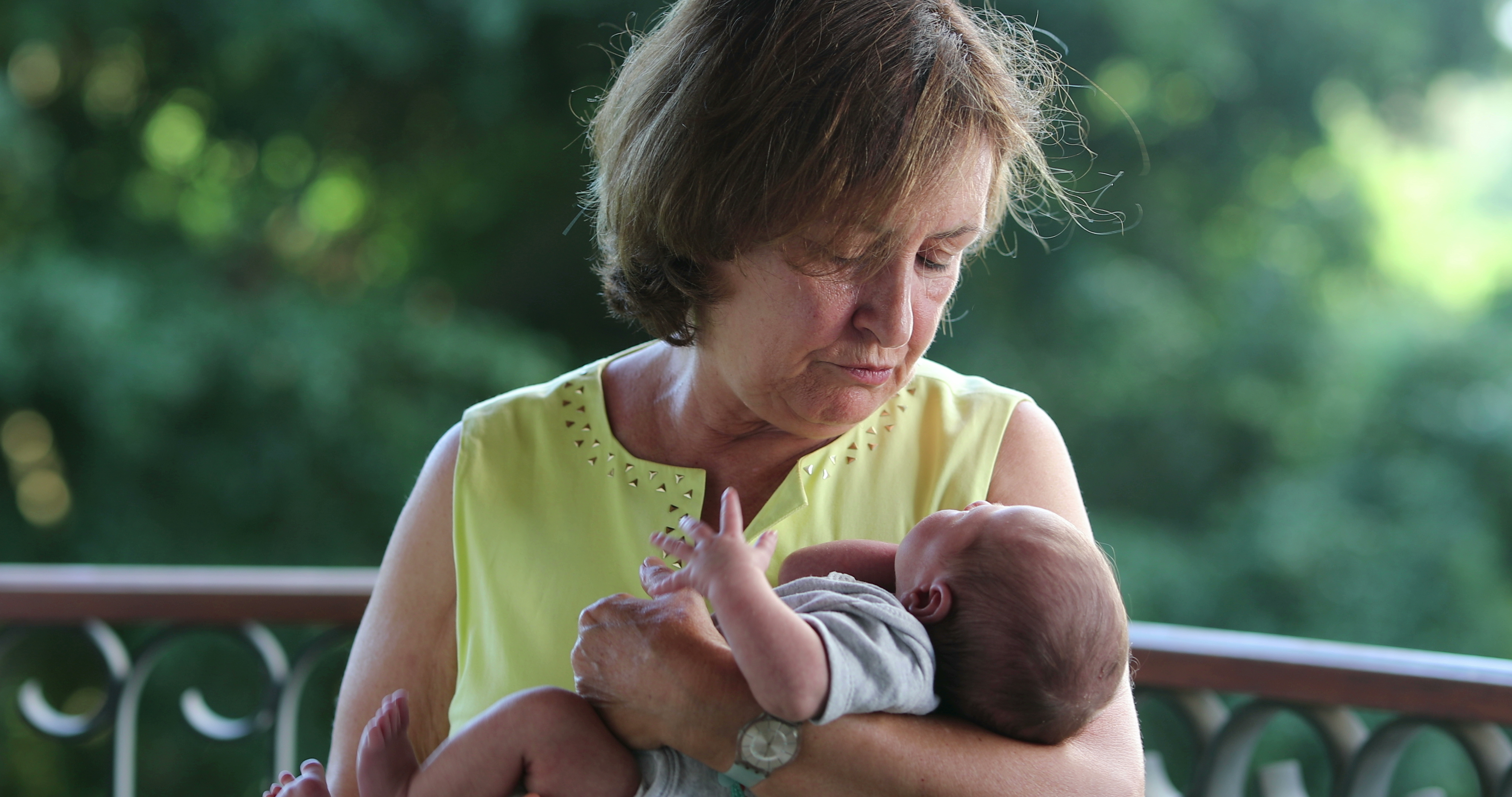 A grandmother holding her newborn grandchild | Source: Shutterstock