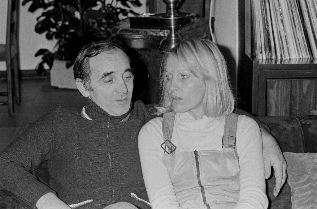 Le compositeur français Charles Aznavour avec sa femme, Ulla Thorsell, à leur domicile de Crans sur Sierre, en Suisse, le 31 décembre 1974. | Photo : Getty Images