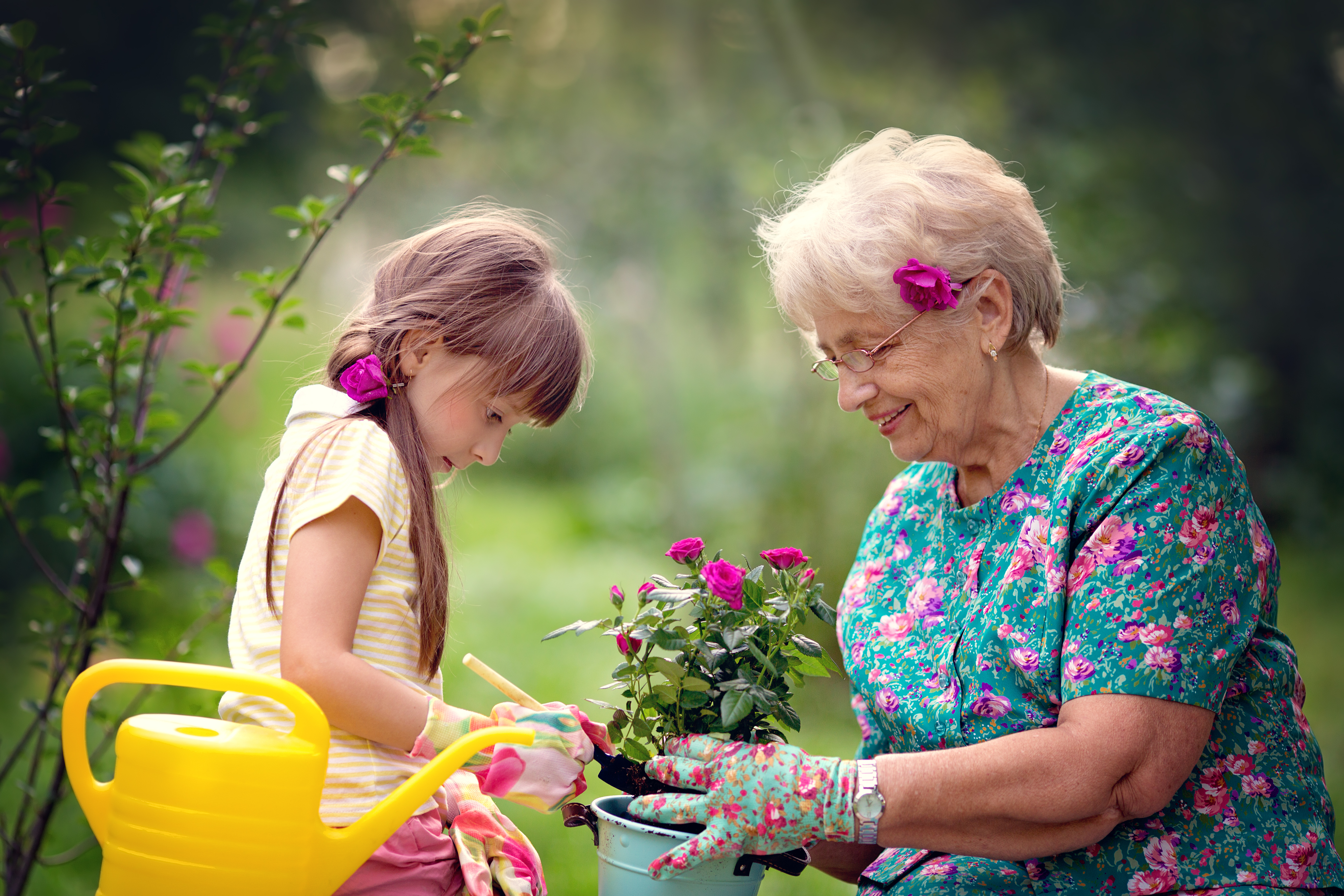 A happy grandmother works in the garden with her little granddaughter. | Source: Shutterstock