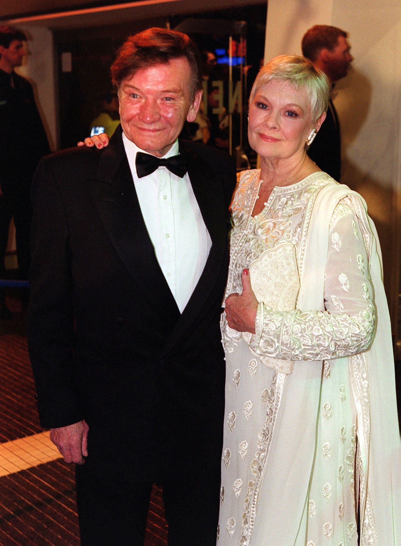 Dame Judi Dench and Michael Williams arrive at the European Charity Premiere of the James Bond film "The World Is Not Enough" at the Odeon Leicester Square, London, on November 22, 1999. | Source: Getty Images