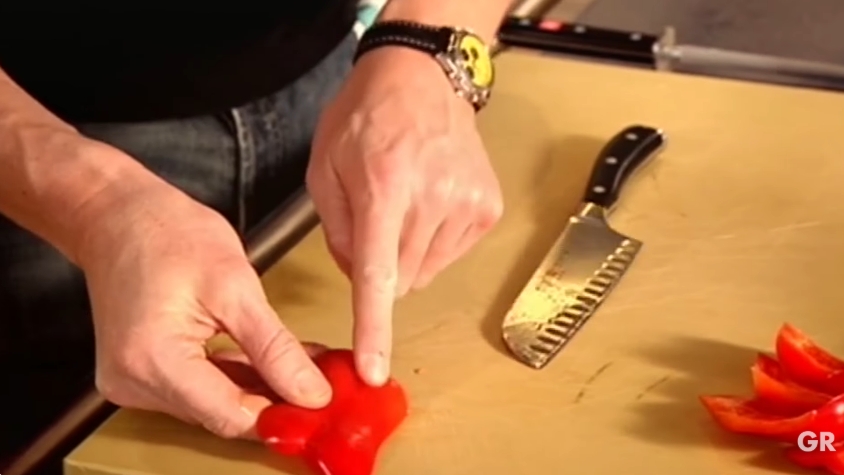 Gordon Ramsay points out where to slice a bell pepper before cutting around the core in one continuous motion. The technique removes the seed cluster cleanly, keeping the chopping board tidy while making it easier to cut the pepper into thin, even strips. | Source: YouTube/ Gordon Ramsay