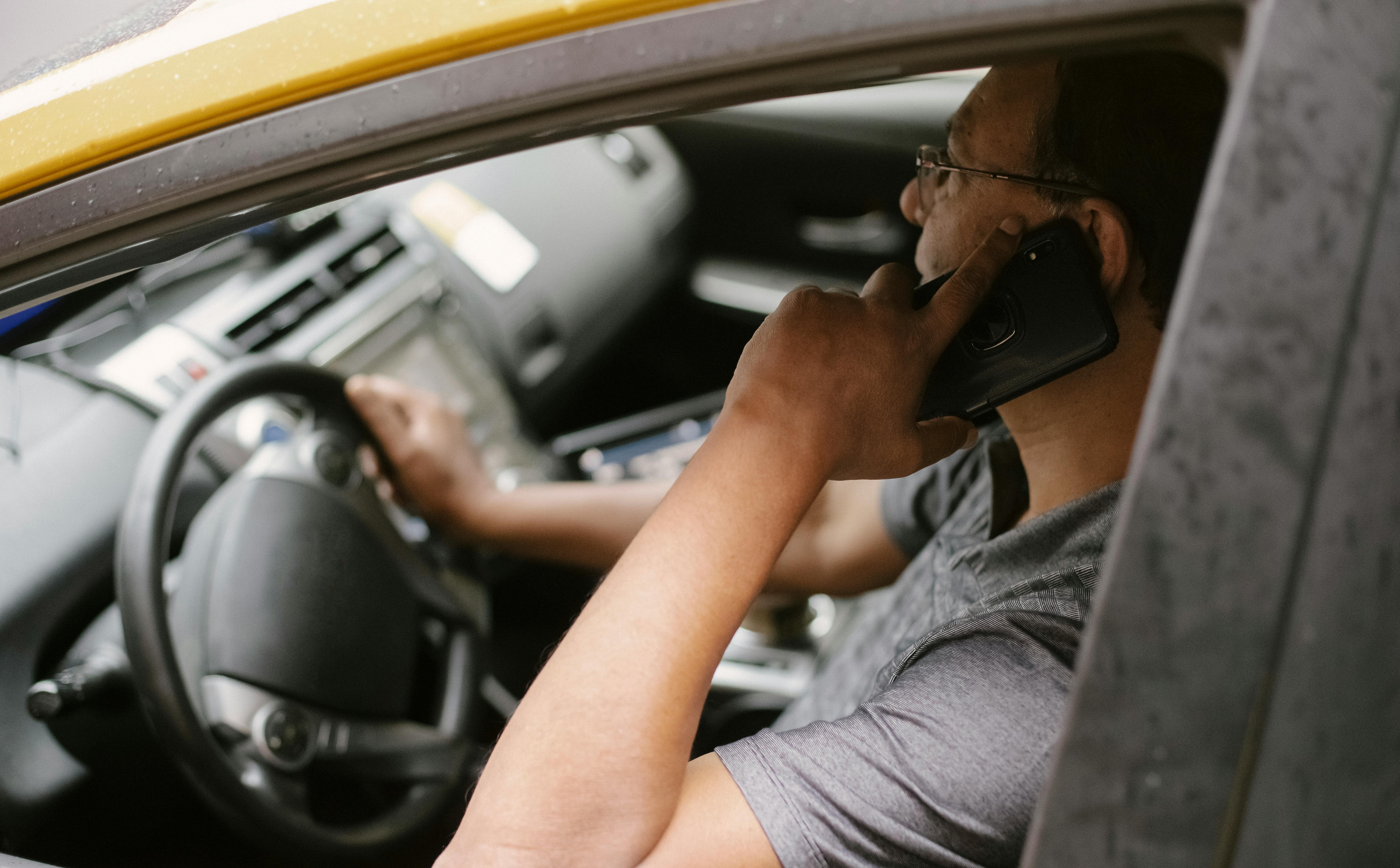 A man driving while talking on a phone | Source: Pexels