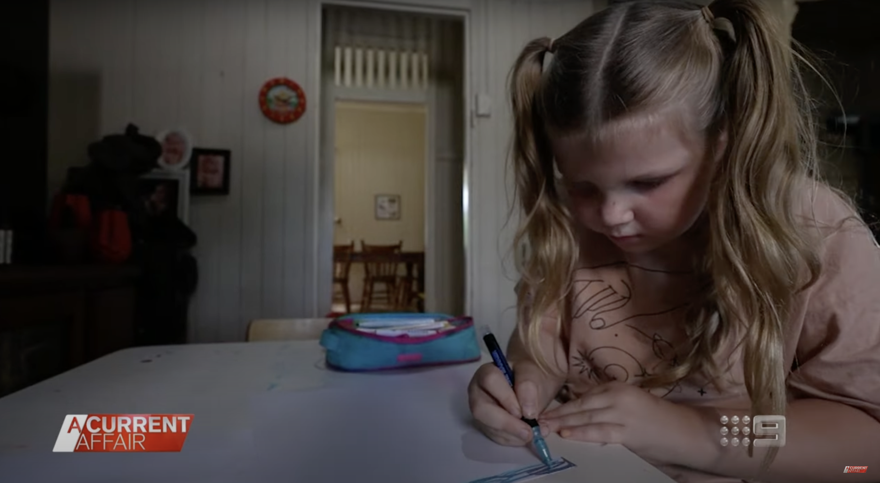 Little Eadie is making drawings on a piece of paper, as seen in a video dated December 5, 2023 | Source: youtube.com/ACurrentAffair9