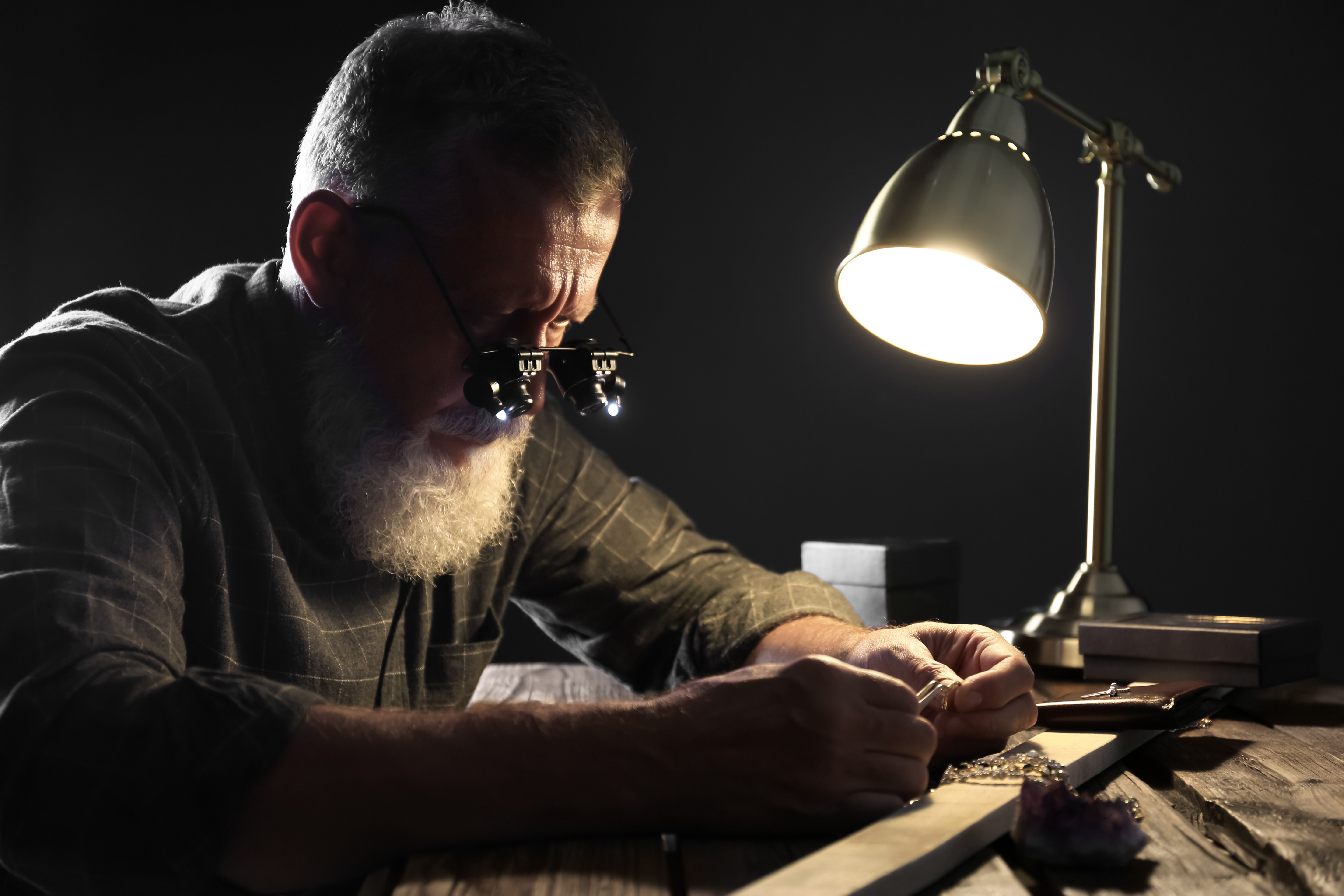 Male jeweler evaluating diamond ring in workshop | Source: Shutterstock.com