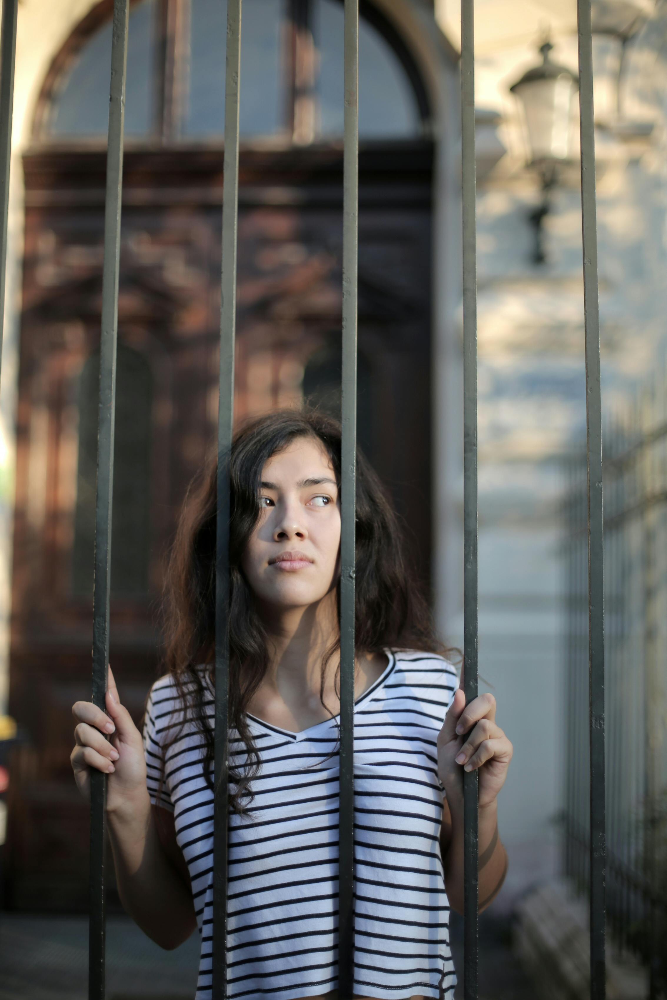 A woman looking through a gate | Source: Pexels