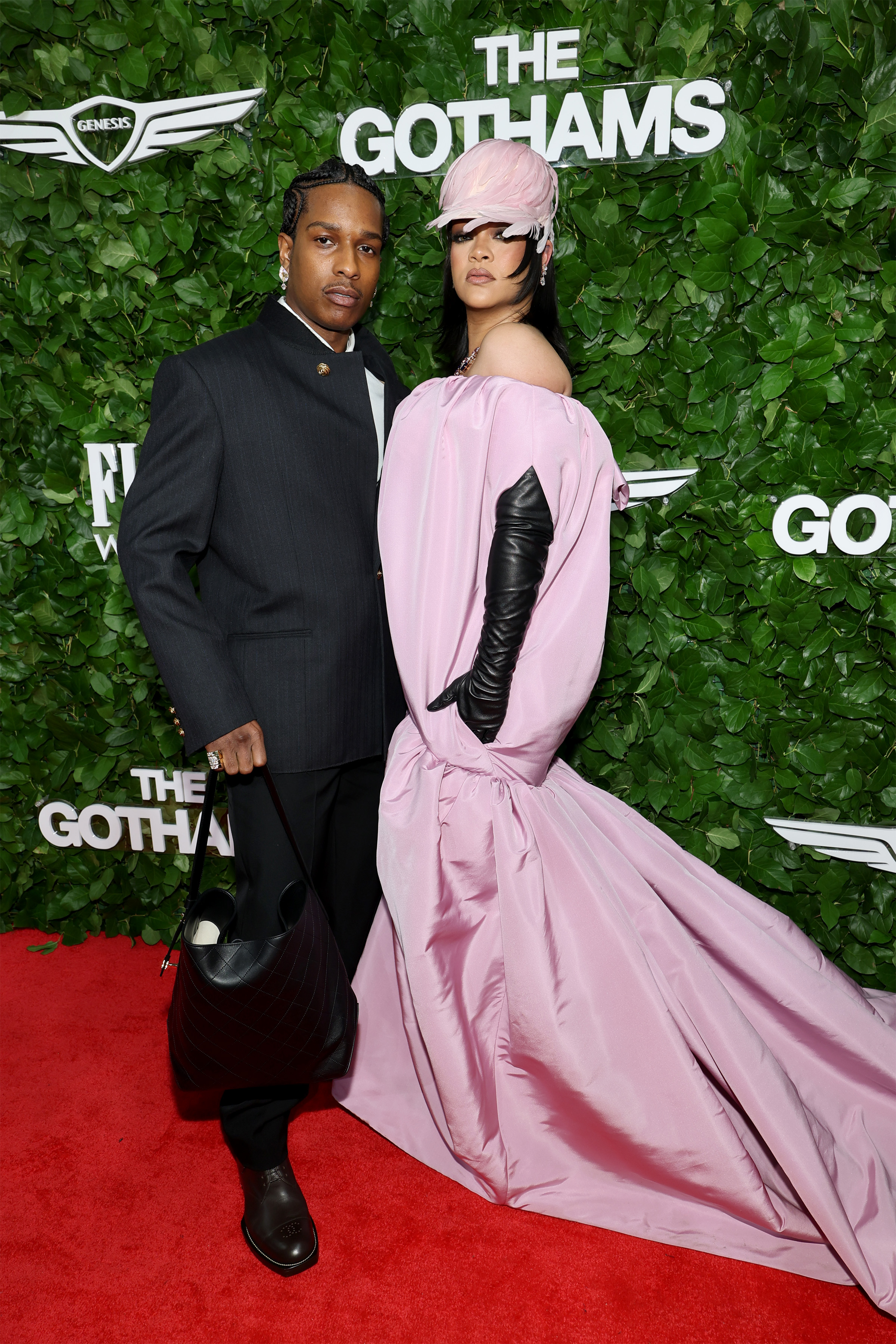 Striking a full-length pose, A$AP Rocky and Rihanna lean into fashion drama — her flowing gown spills across the carpet while he keeps it cool in a structured, all-black ensemble.