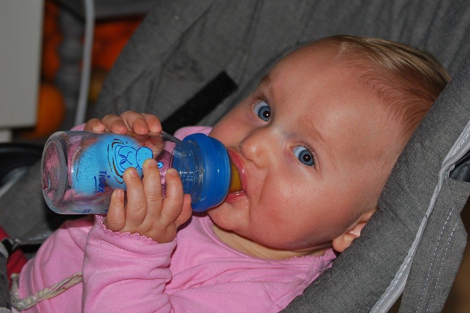Baby mit Flasche guckt in die Kamera | Quelle: Pixabay
