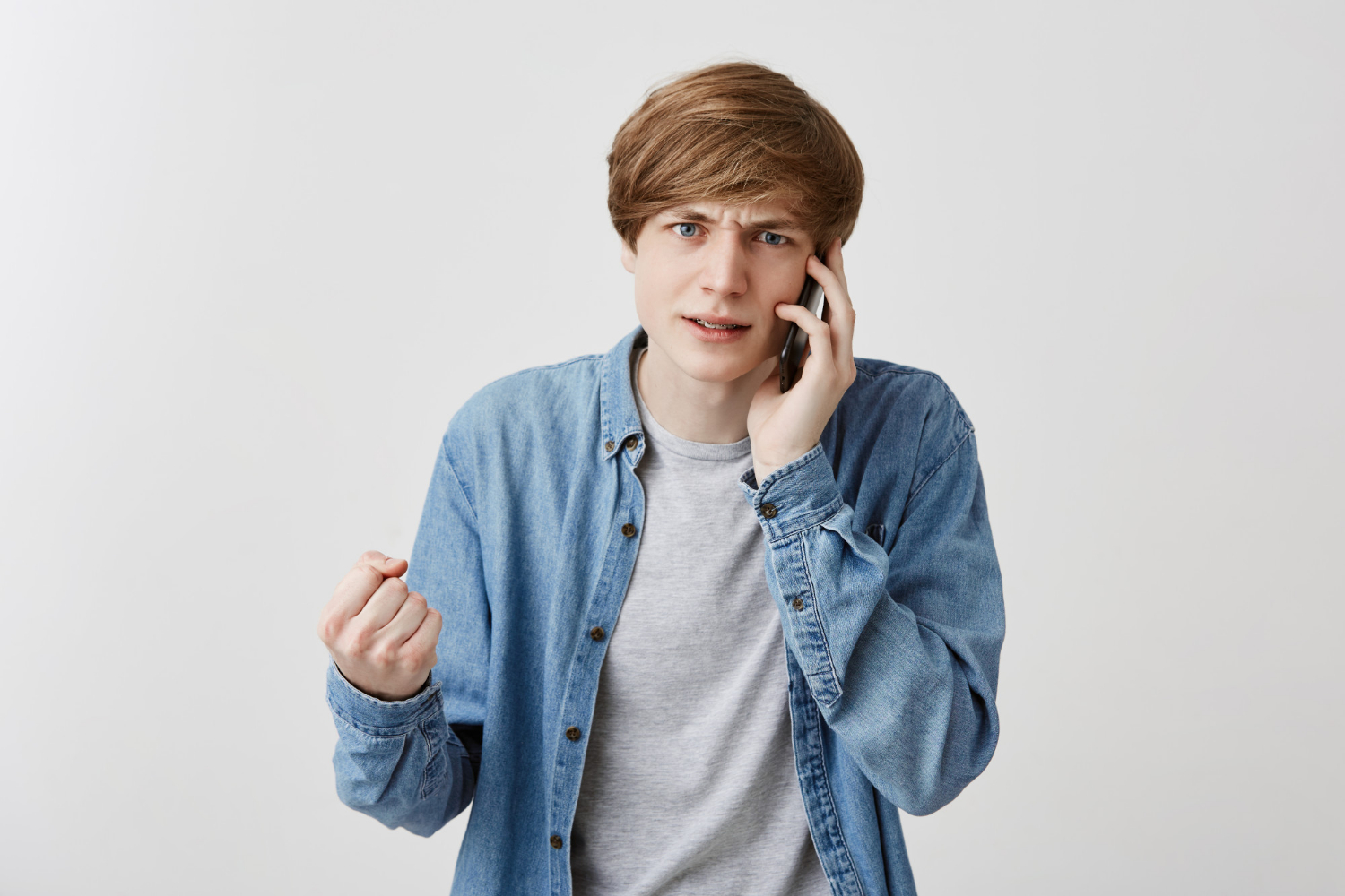 A frantic young man talking on the phone | Source: Freepik