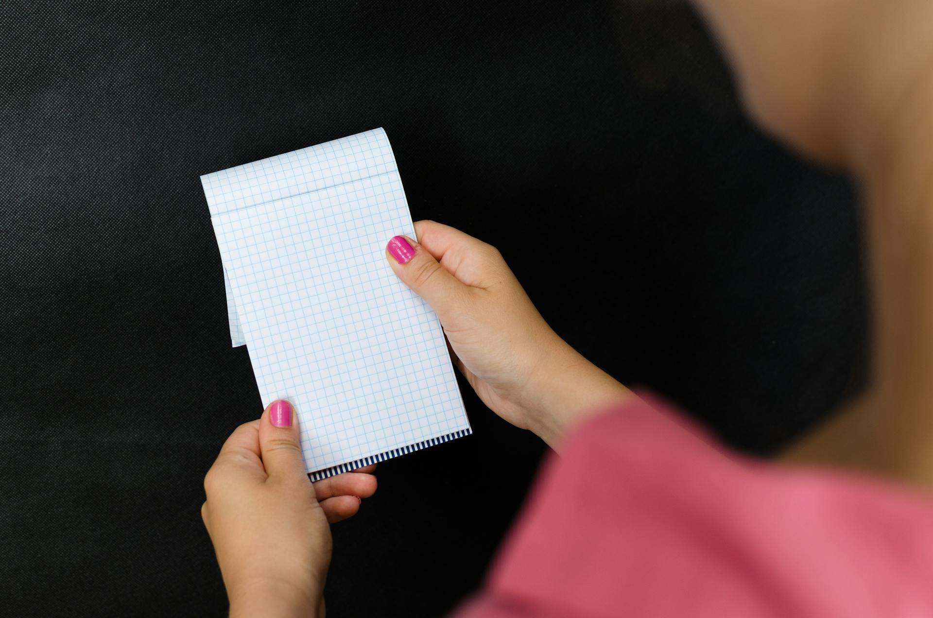A woman holding a notepad | Source: Pexels