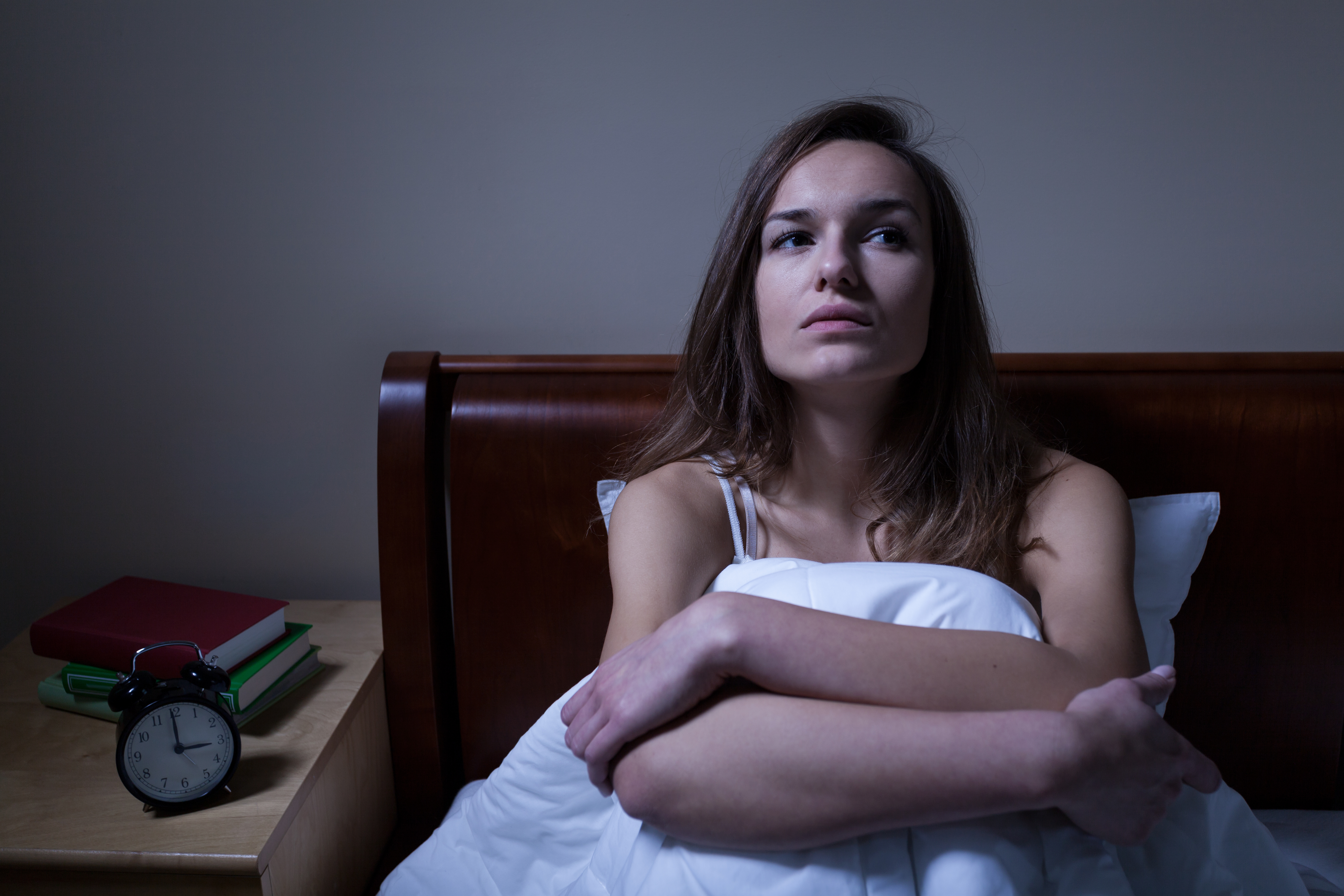 A woman sitting in bed | Source: Shutterstock