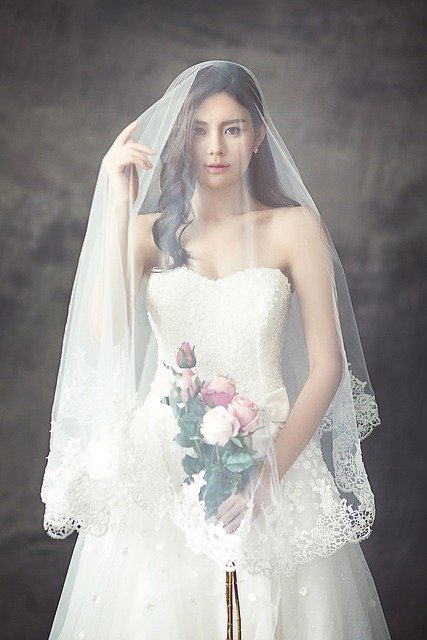 Woman wears white wedding dress with veil and bouquet | Photo: Pixabay