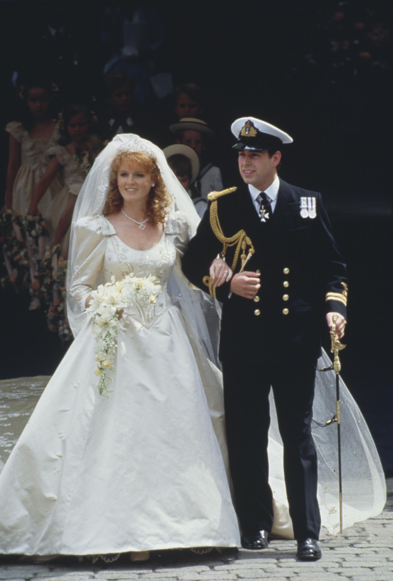 Sarah Ferguson and Andrew Mounbatten Windsor arm-in-arm following their wedding ceremony at Westminster Abbey on 23 July 1986 in London, England. | Source: Getty Images