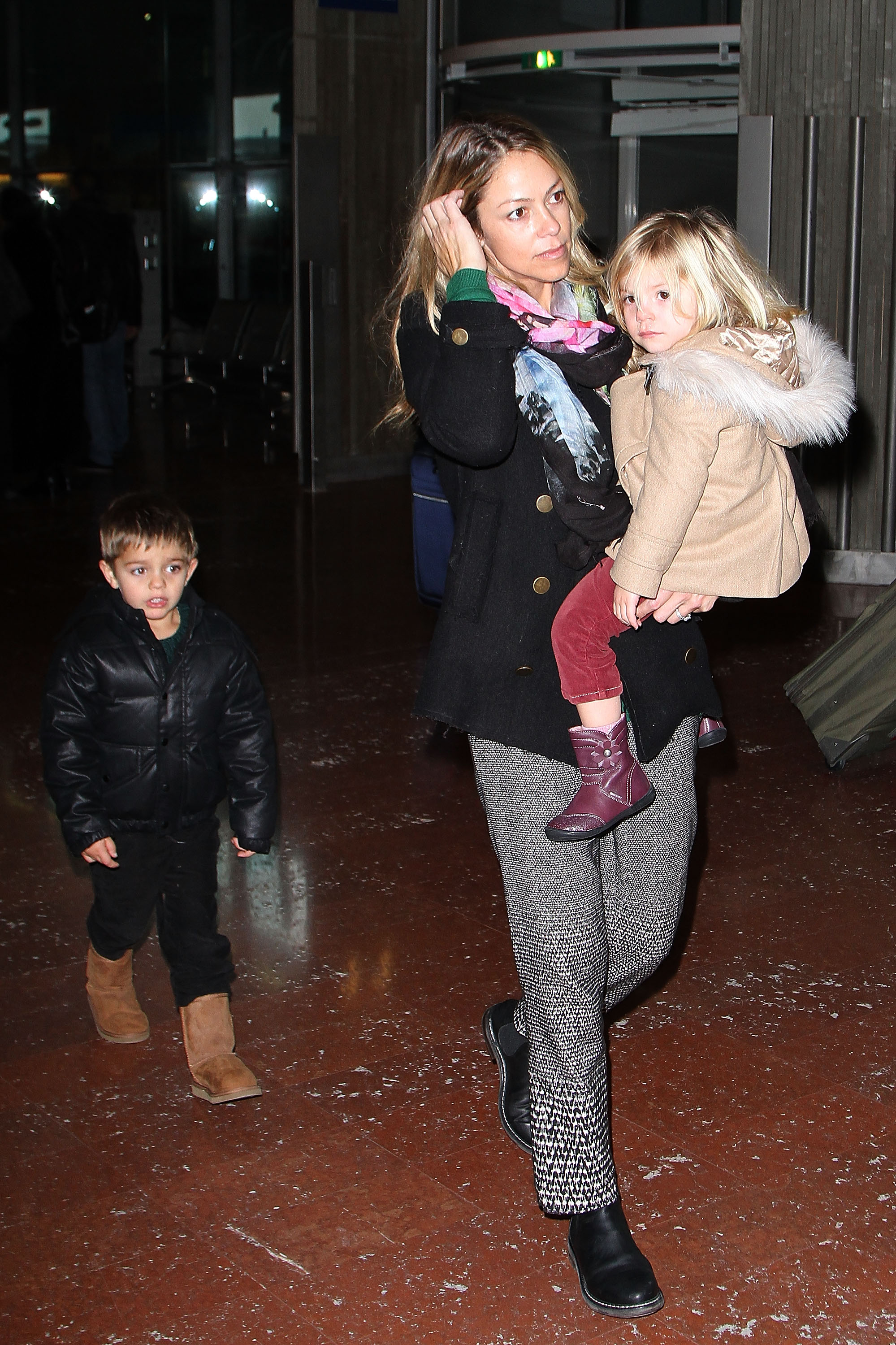 Christine Baumgartner, her son Hayes, and her daughter Grace Avery Costner seen at Roissy Airport on January 15, 2013, in Paris, France | Source: Getty Images